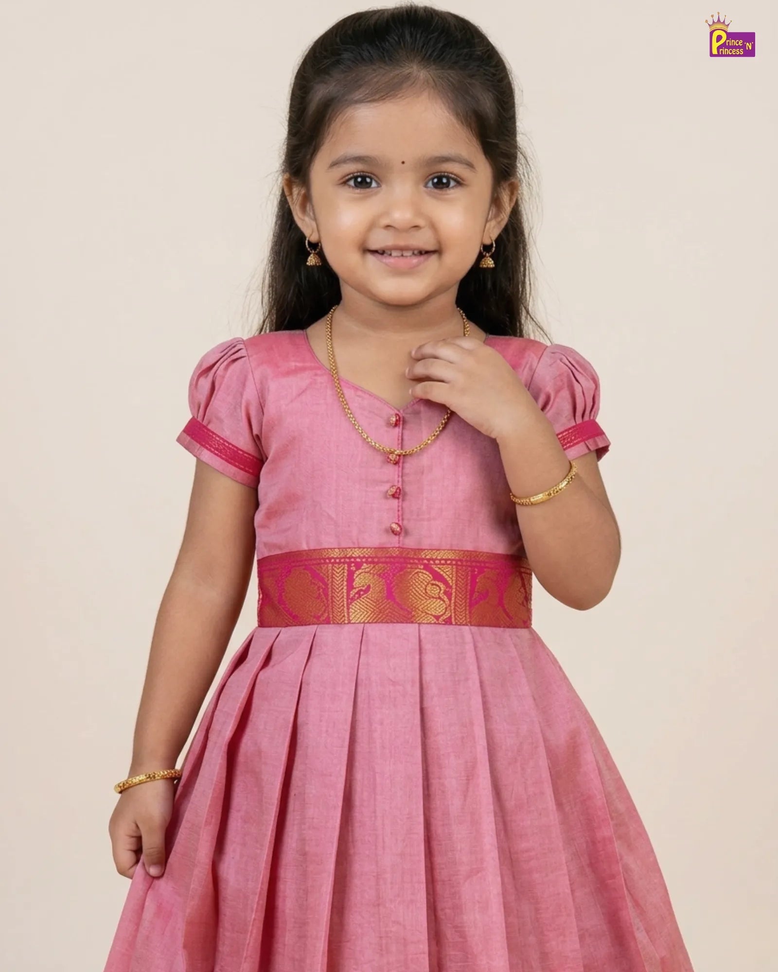 Young girl wearing a pink traditional dress with a decorative belt on a beige background