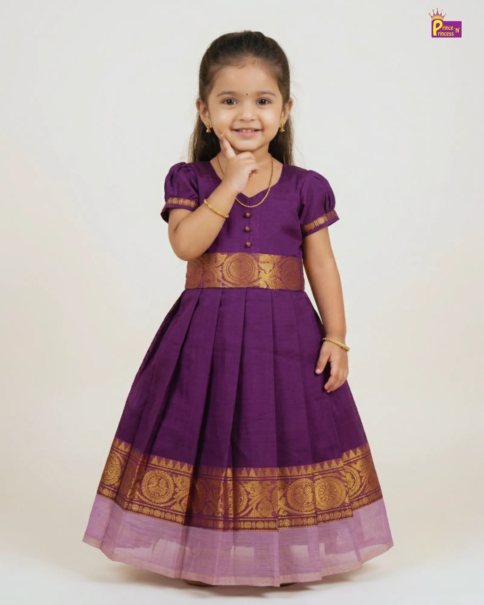 Young girl wearing a purple traditional dress with gold accents on a white background