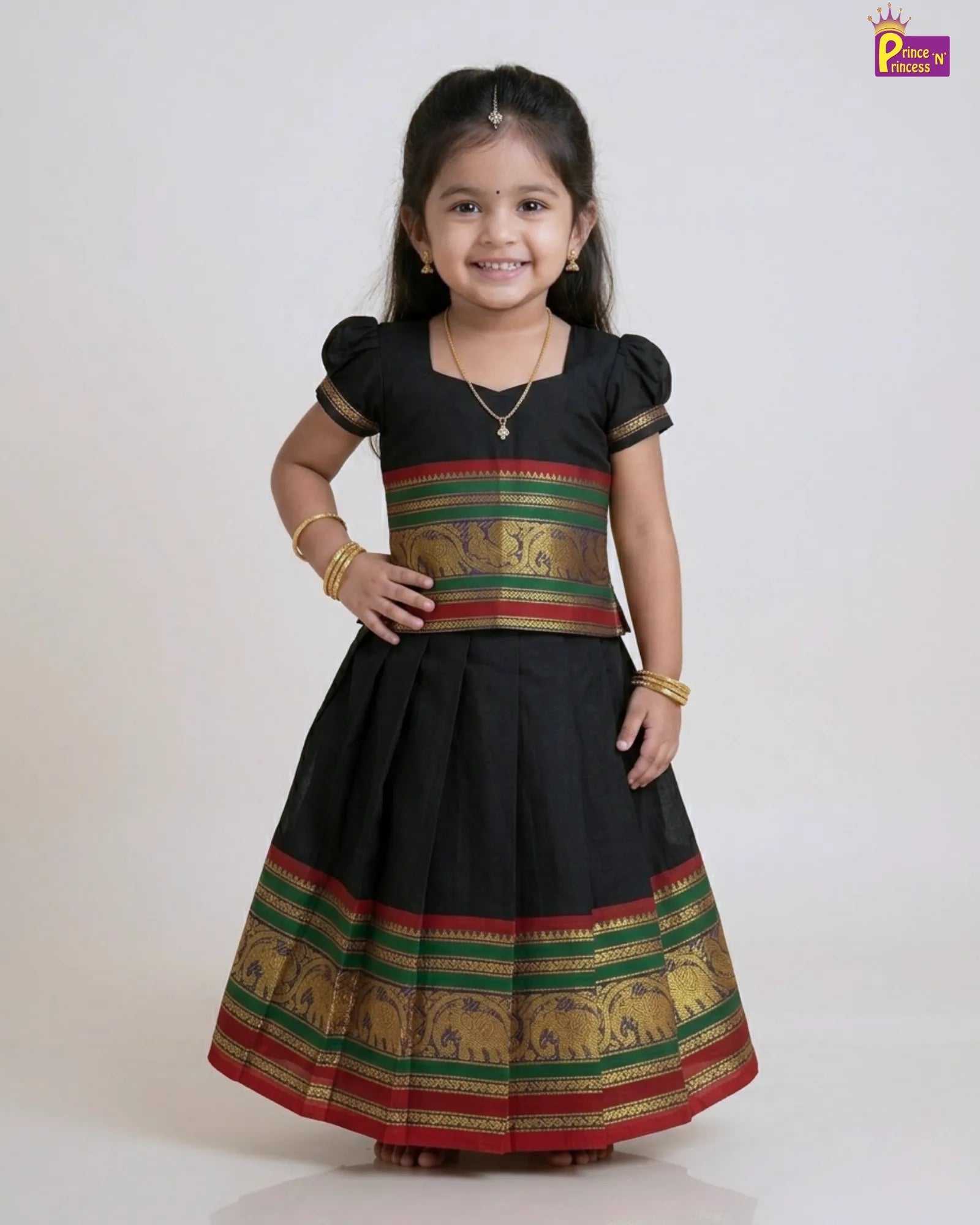 Young girl wearing a traditional black dress with colorful patterns on a white background