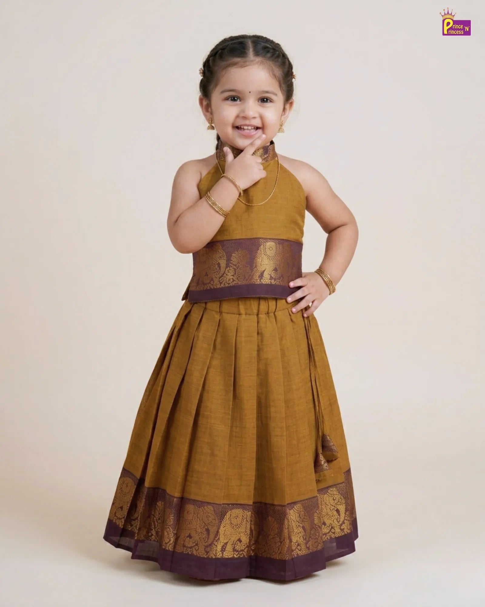 Young girl wearing a mustard yellow and brown traditional dress on a beige background