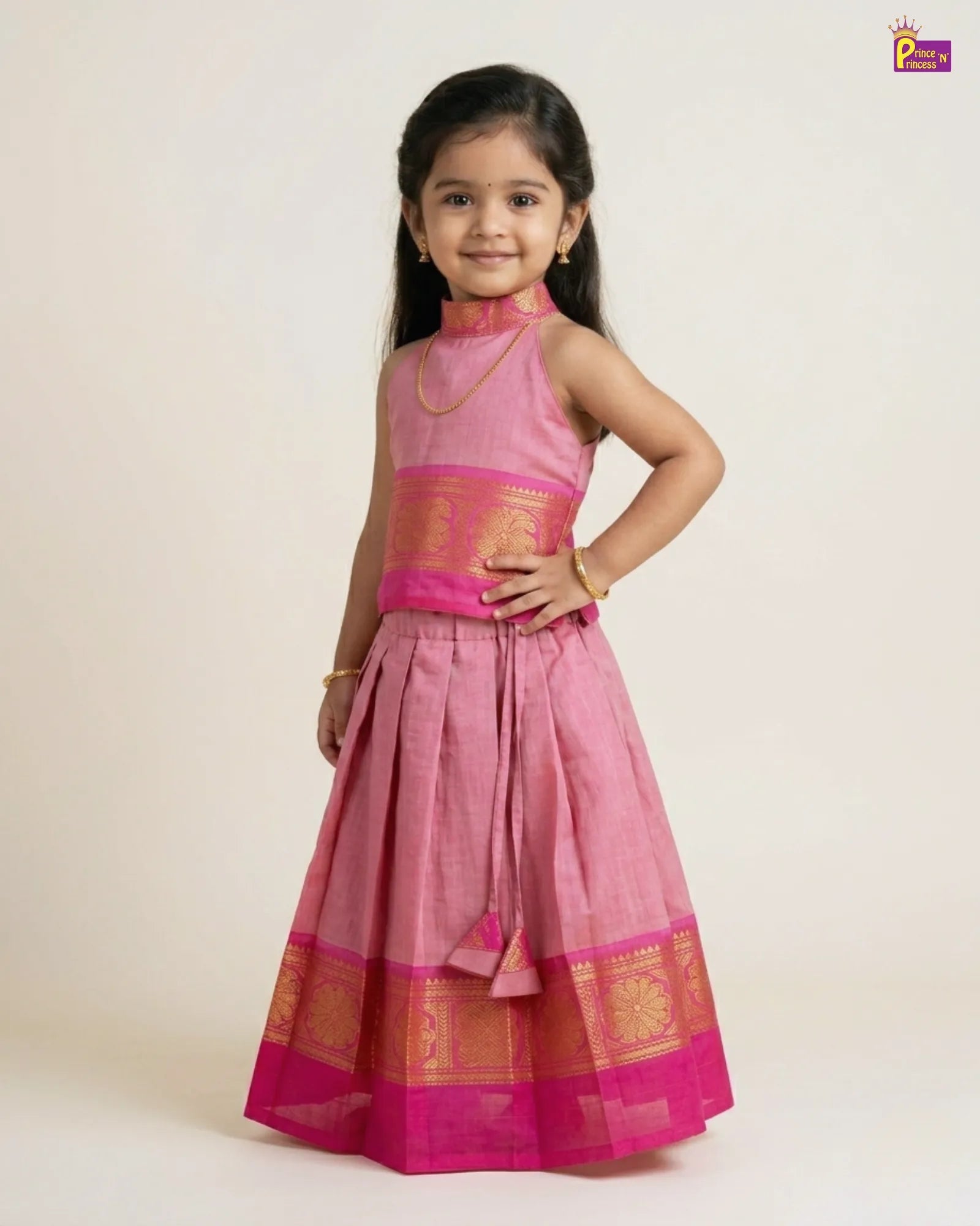 Young girl wearing a pink traditional outfit with gold accents on a beige background