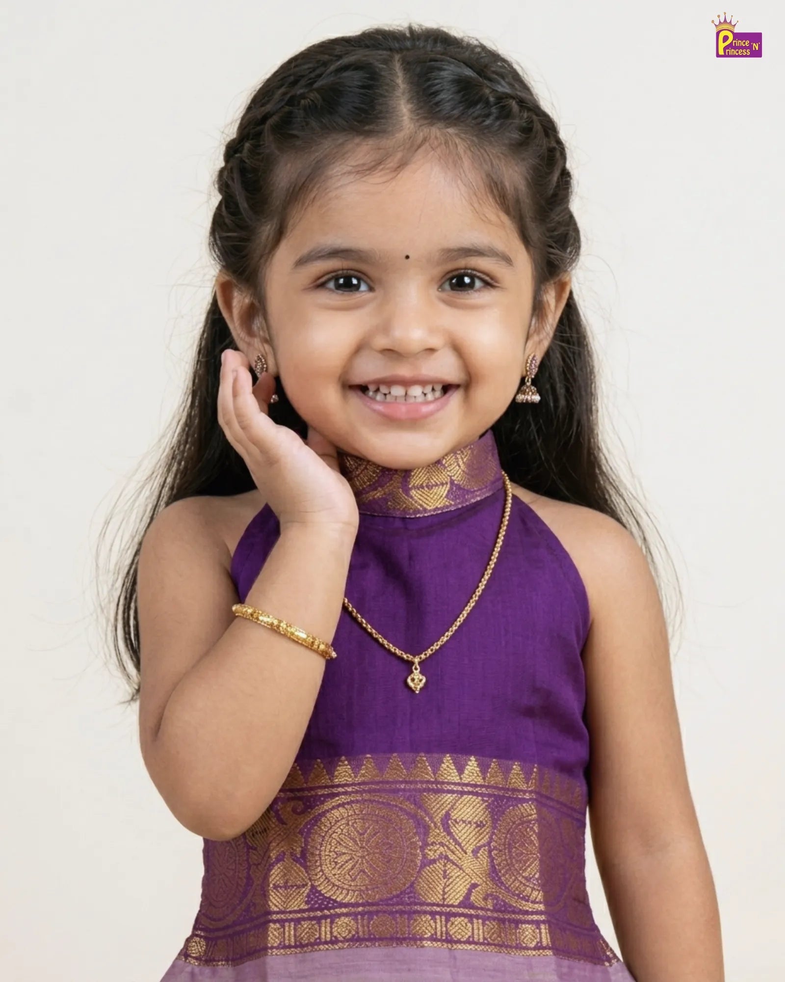 Young girl in a purple traditional outfit with gold accents on a white background