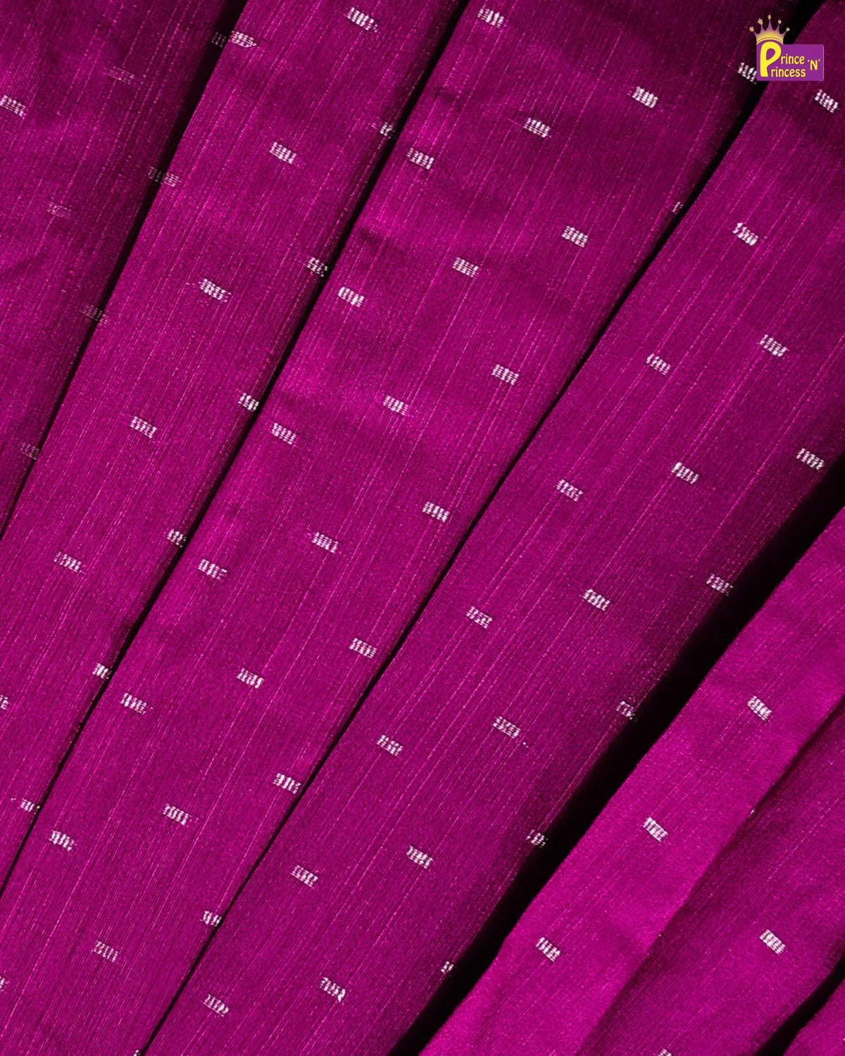 A close-up of folded magenta-purple fabric with a fine vertical texture and small repeating white printed text, shown against a matching fabric background.