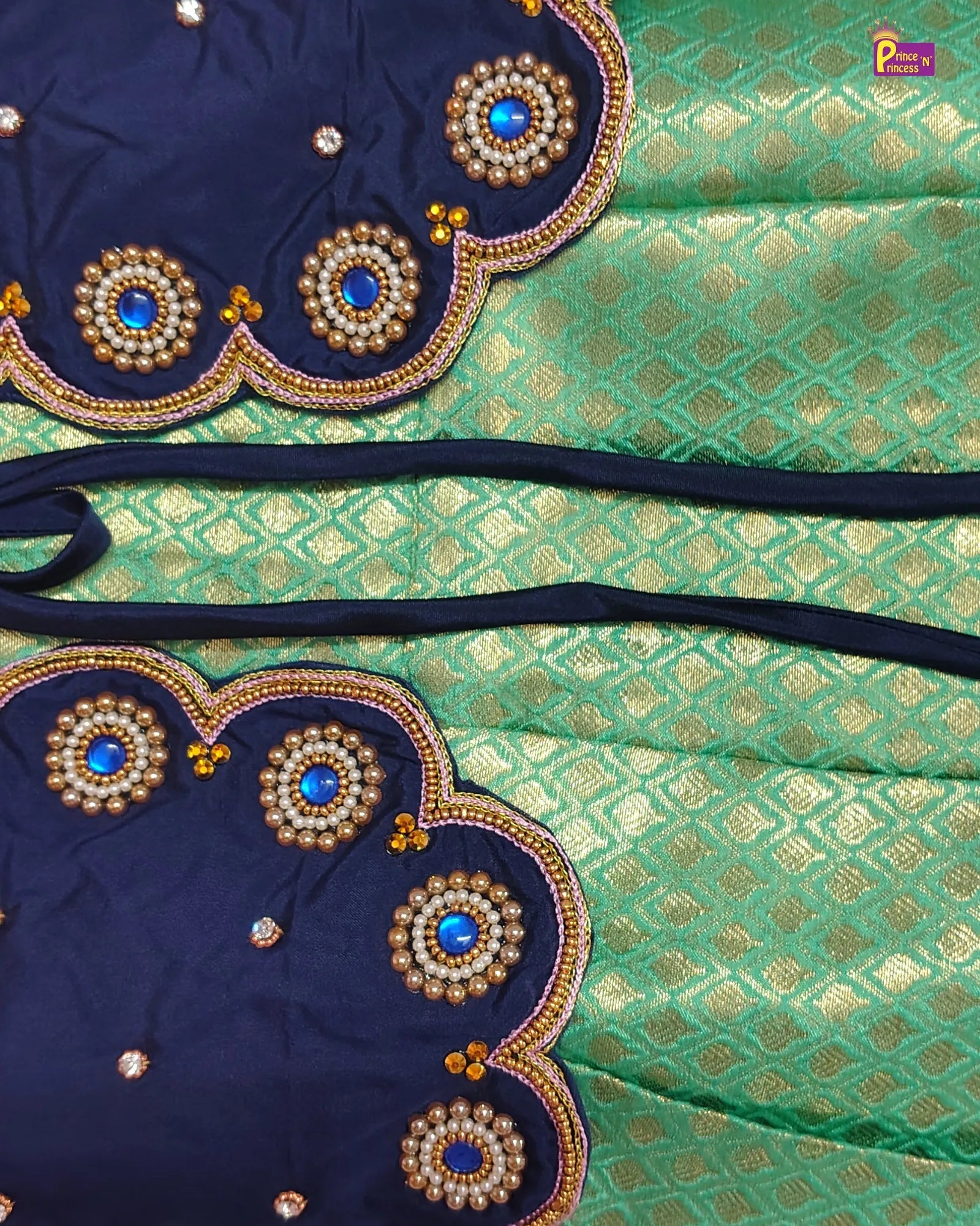 Decorative blouse with embroidered details on a green and blue fabric background