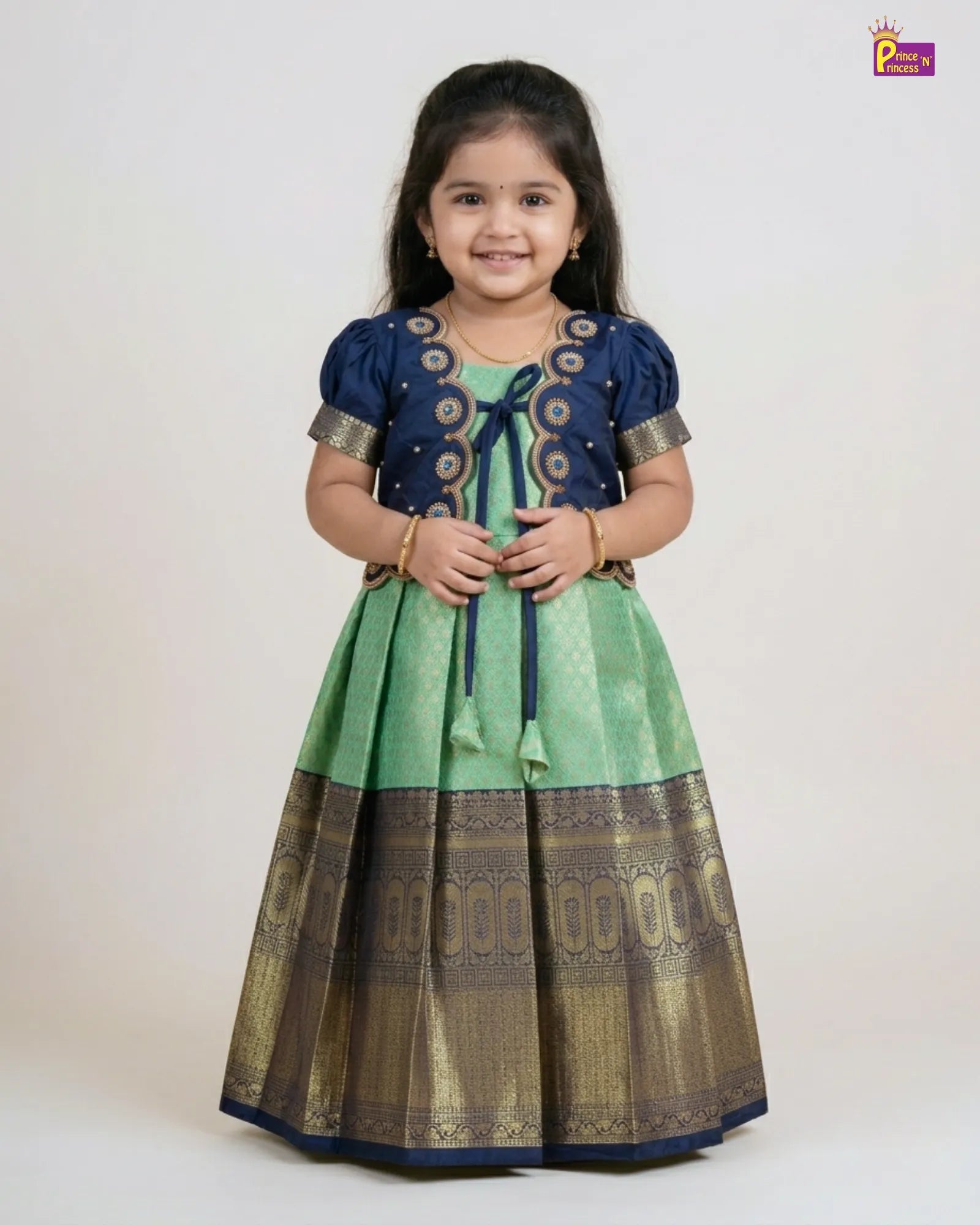 Young girl wearing a traditional outfit with a blue and green dress on a white background