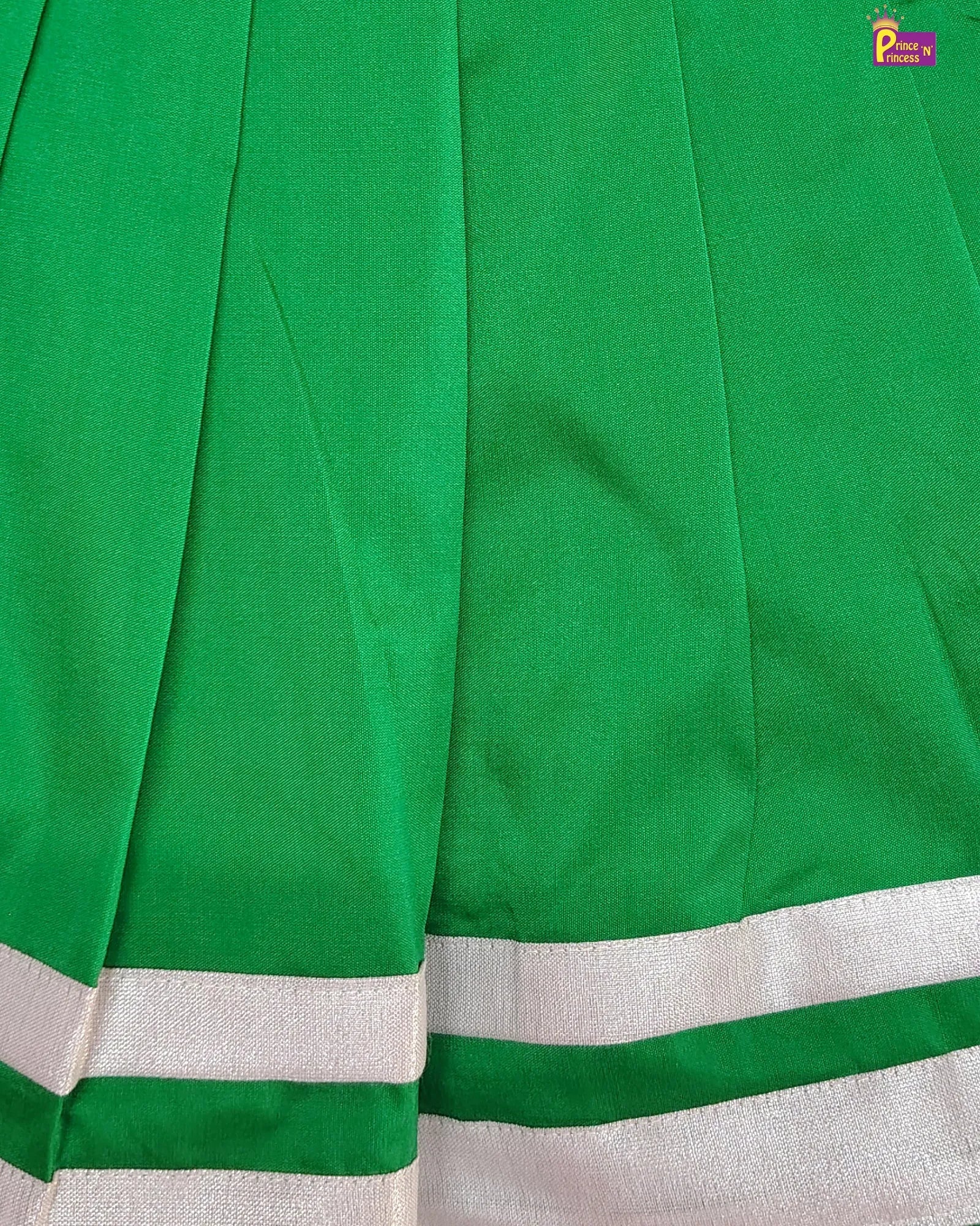Close-up of green fabric with white border, brand logo visible