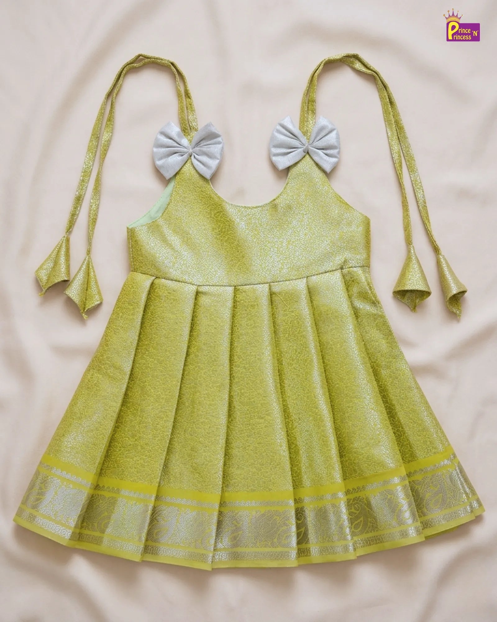 Yellow dress with bow straps on a light pink background