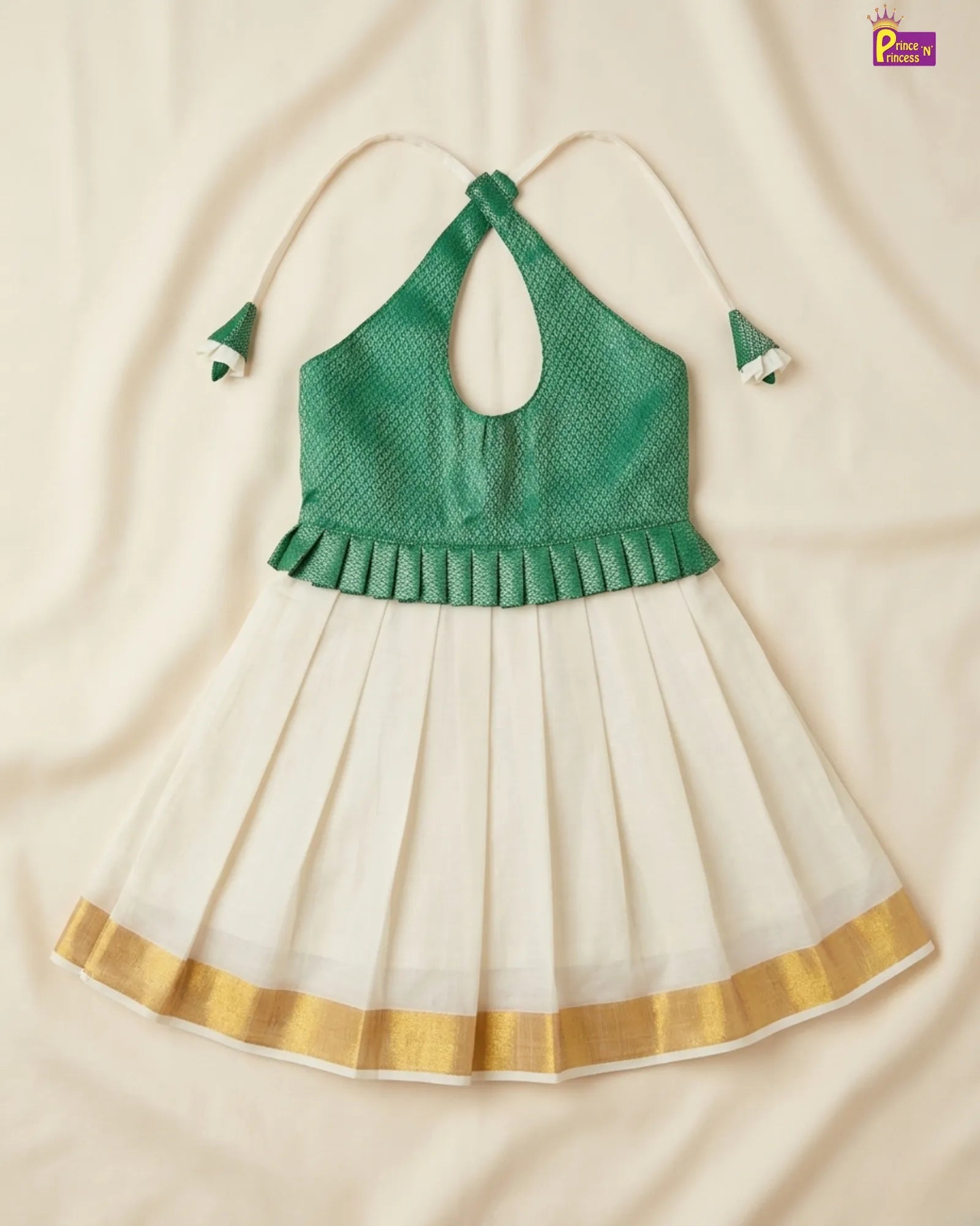 Green top and white skirt with gold trim on a beige background