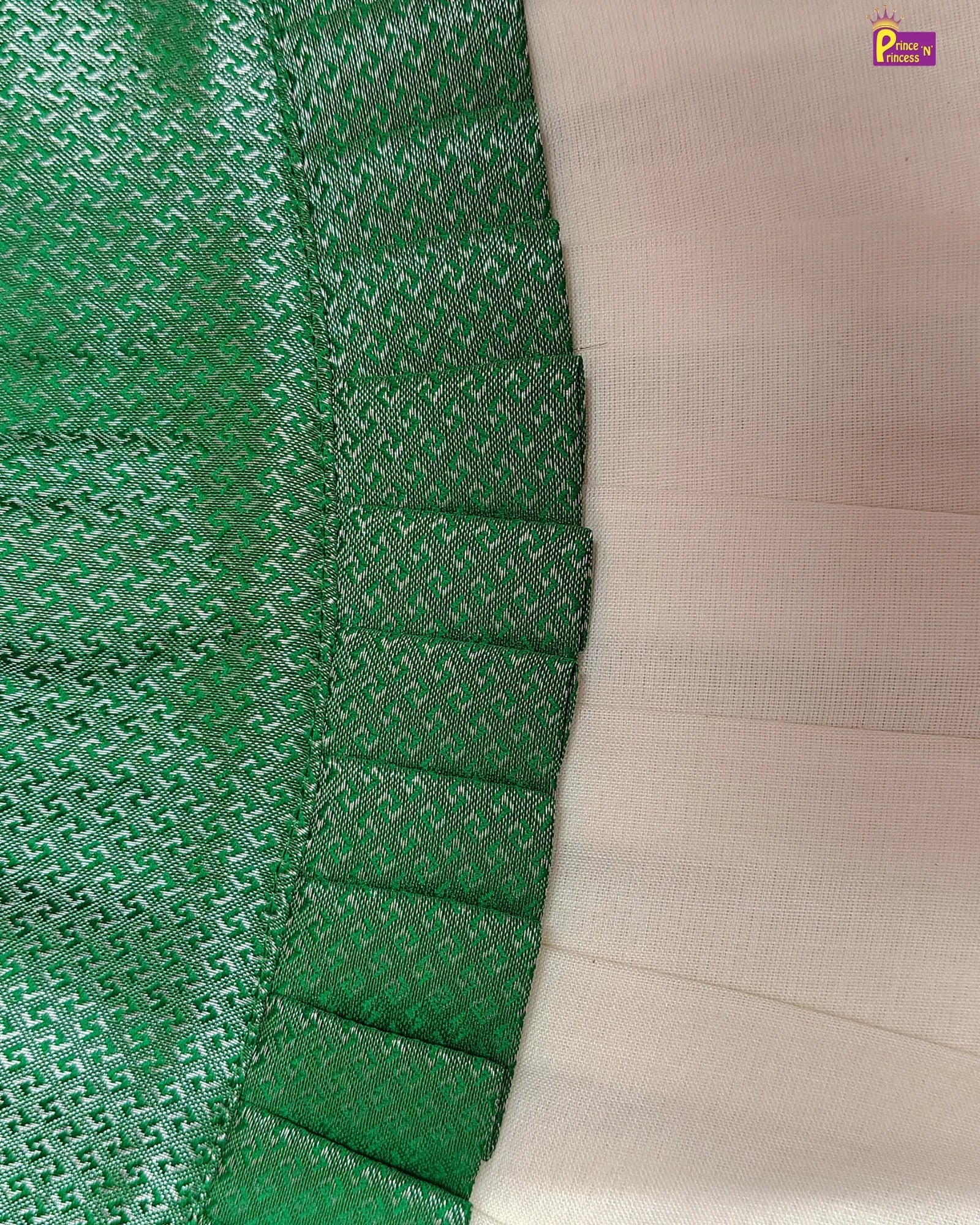 Close-up of green fabric with a textured pattern and beige fabric on the right.