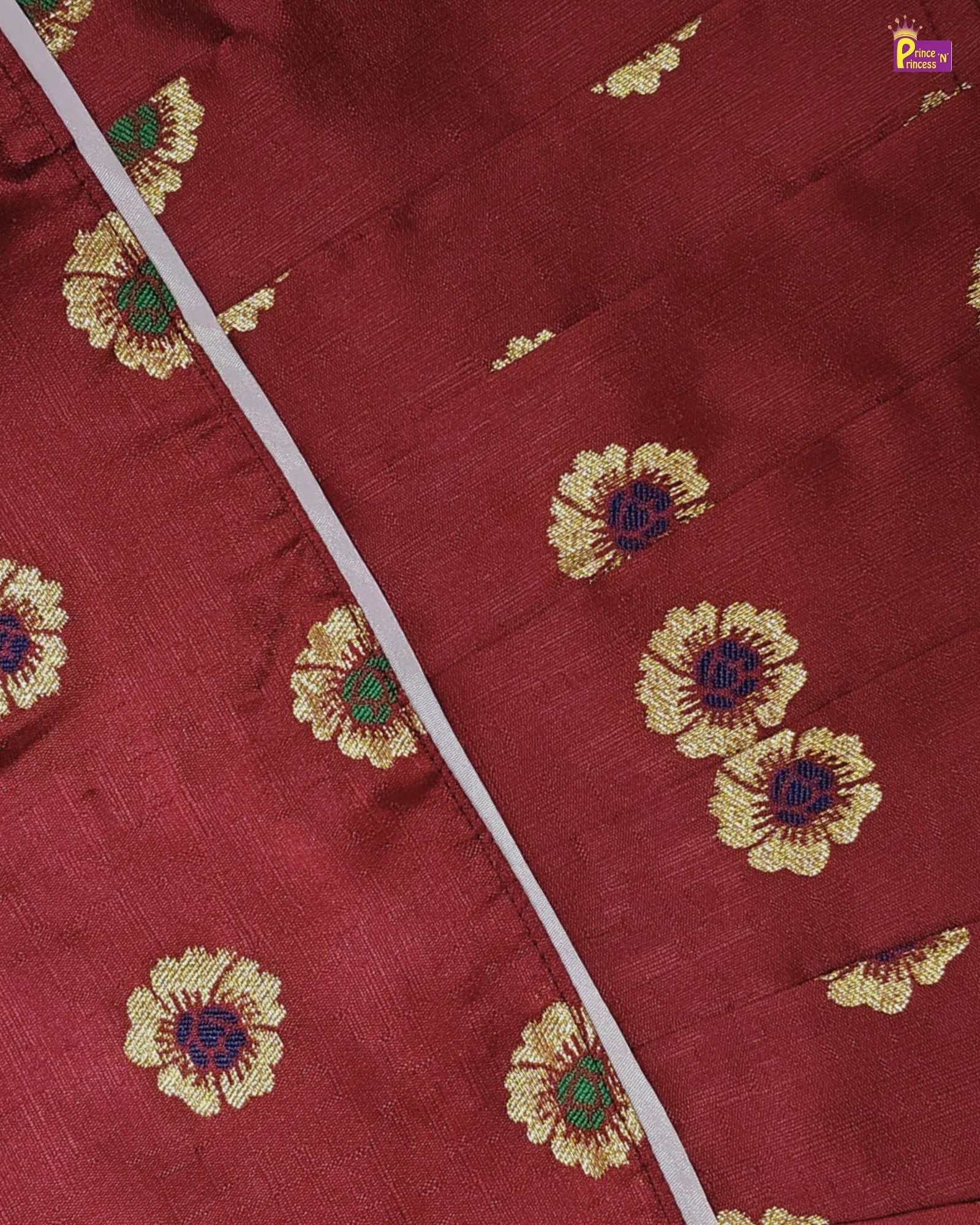 Close-up of a red fabric with gold floral embroidery