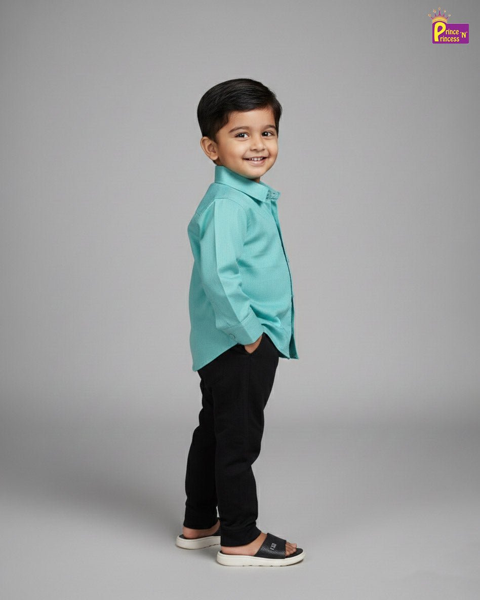 Child wearing a turquoise shirt and black pants on a gray background - Prince N Princss