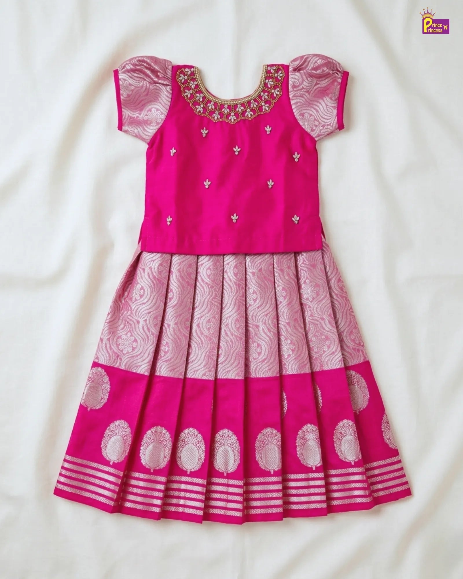 Pink traditional outfit with intricate patterns on a white background