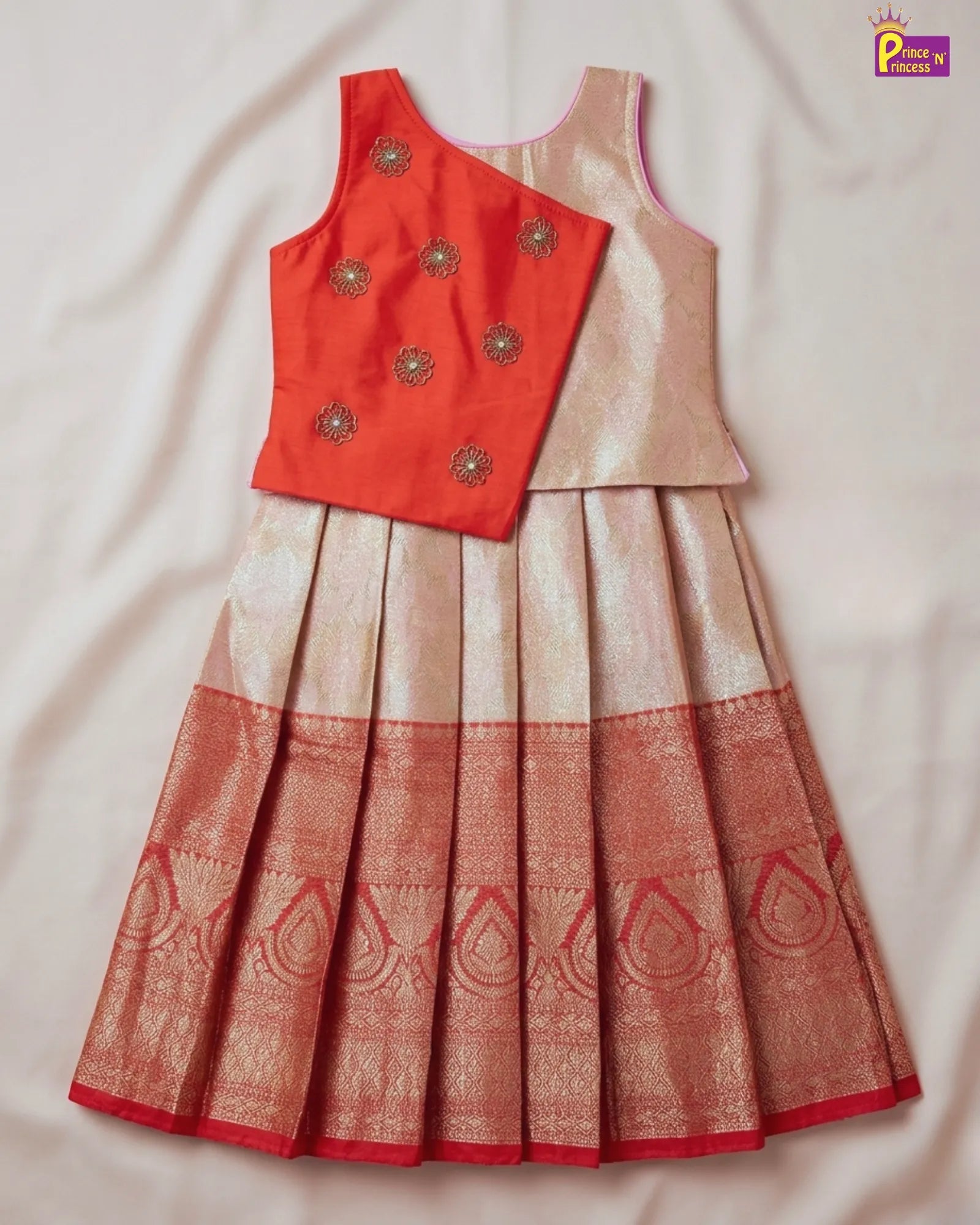 Red and beige traditional outfit with intricate patterns on a light background