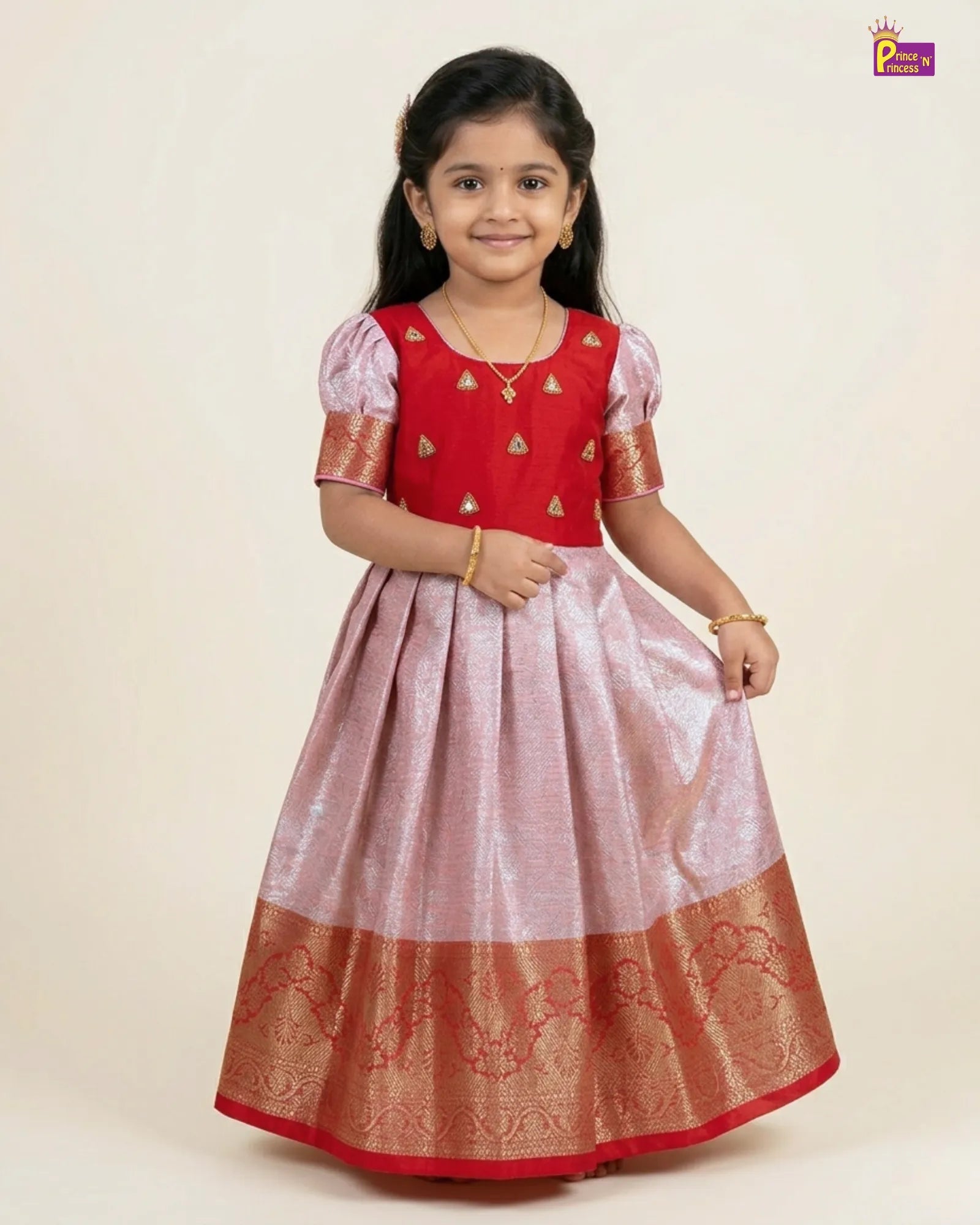 Young girl wearing a red and pink traditional outfit with gold details on a beige background
