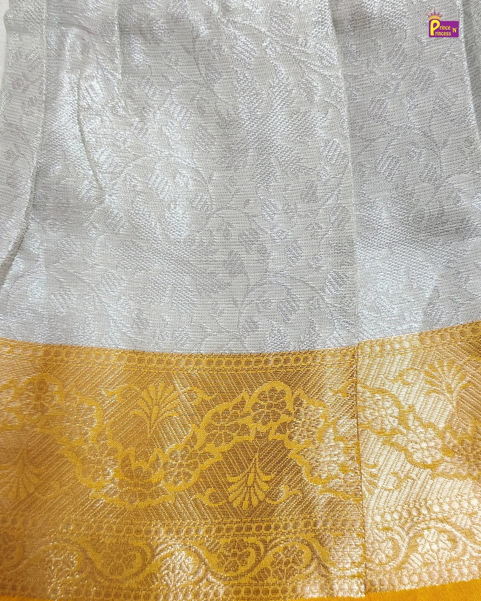 White fabric with gold embroidery at the bottom