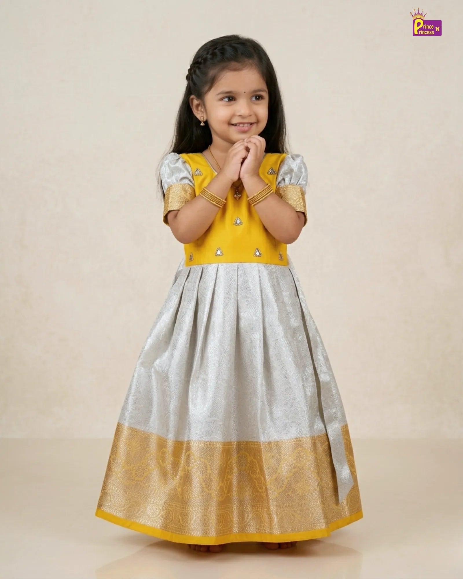 Young girl wearing a yellow and gray traditional dress on a beige background