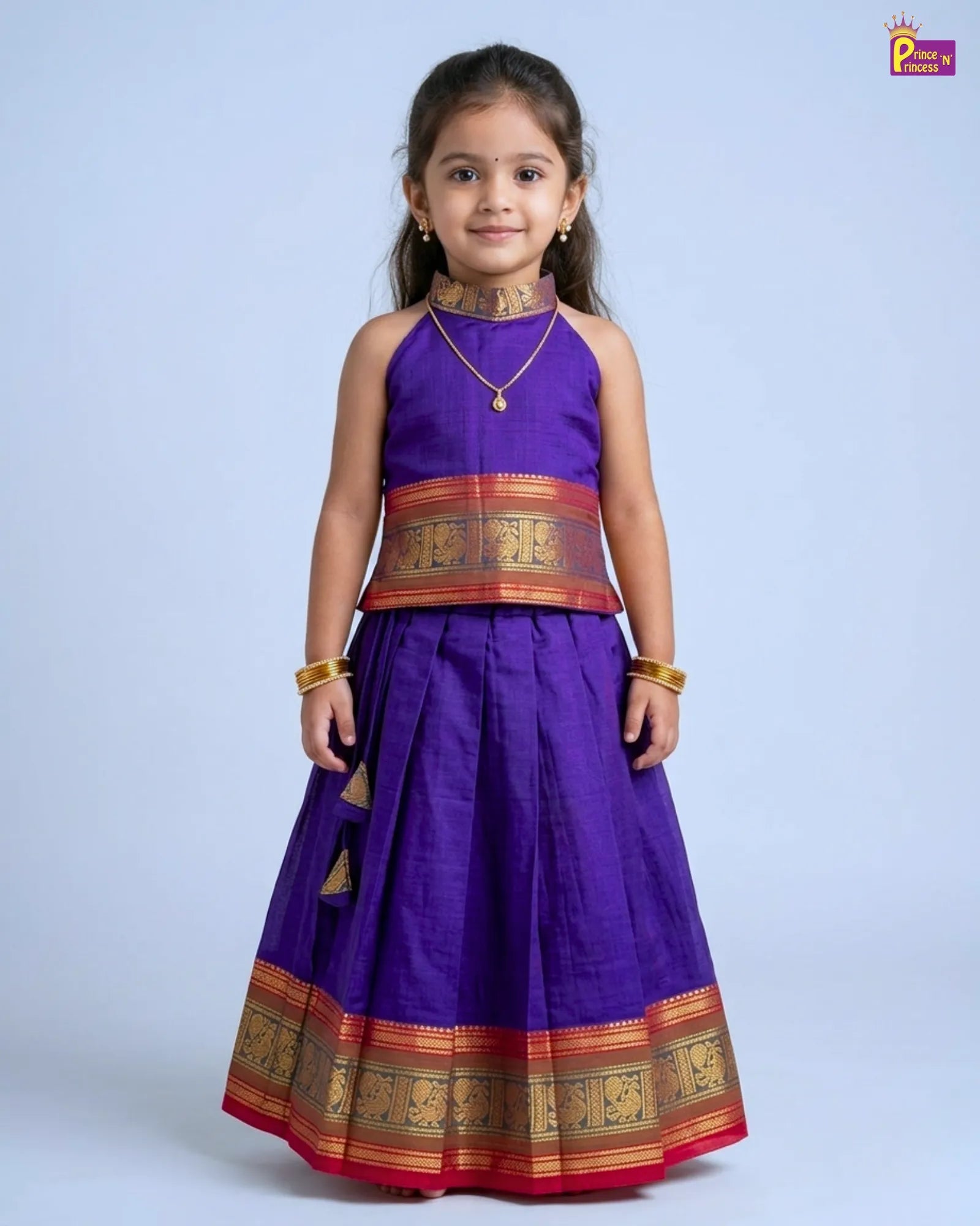 Young girl wearing a traditional purple and gold outfit on a light gray background