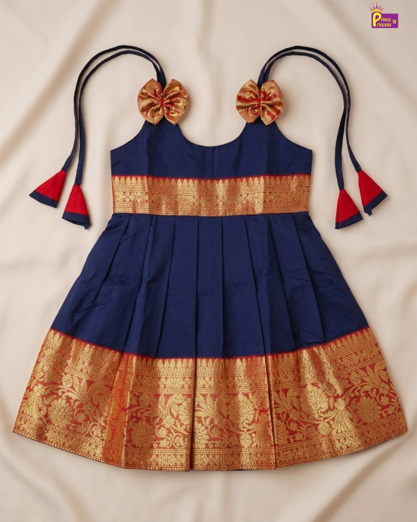 Blue and gold traditional dress with decorative hair accessories on a beige background