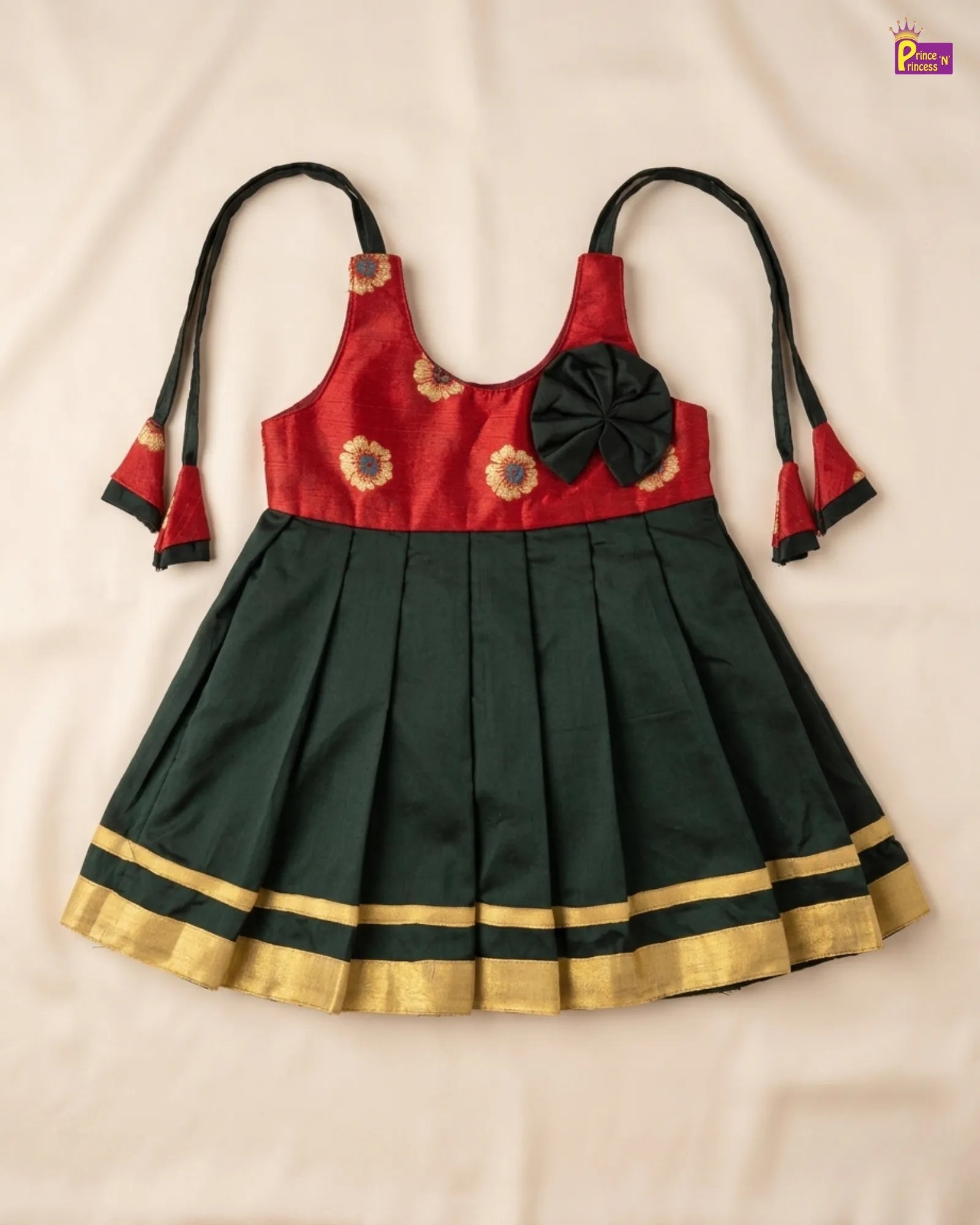 Traditional outfit with red top and green pleated skirt on a beige background