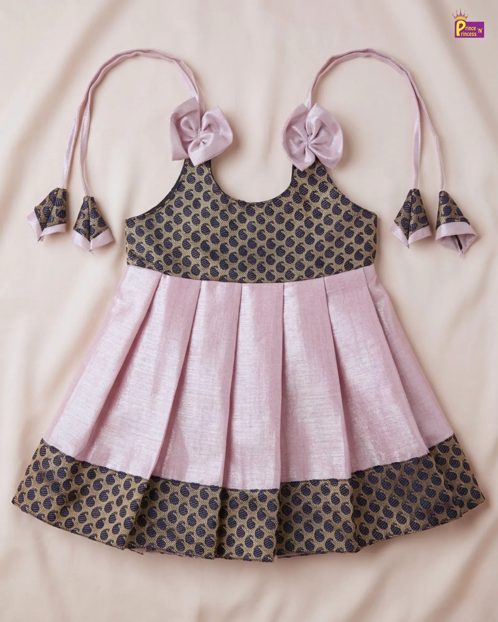 Children's dress with pink and black pattern on a beige background
