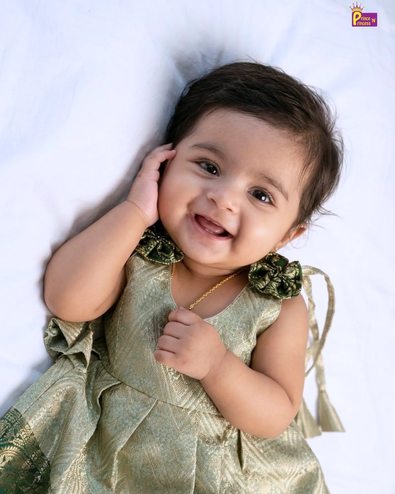 close up view baby lie down on bed with wearing our premium pattu frock banarasi silk