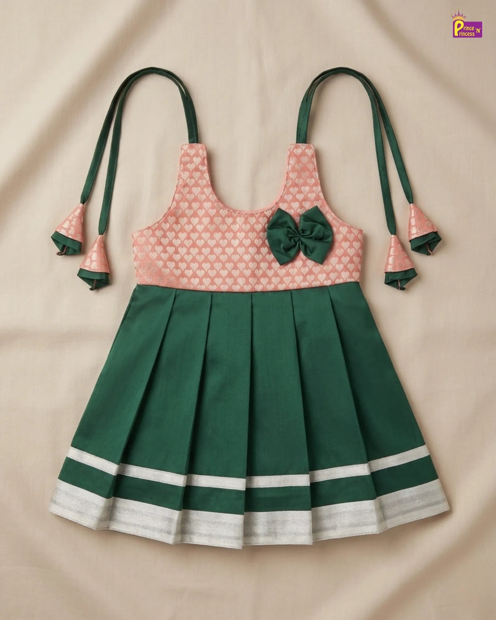 Green and pink dress with bow on a beige background