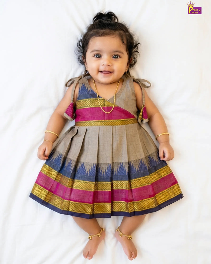 Baby wearing a colorful traditional dress on a white background