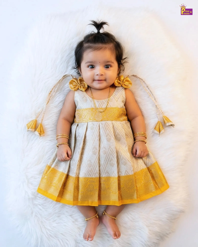 Baby in a white and yellow dress with angel wings on a white background