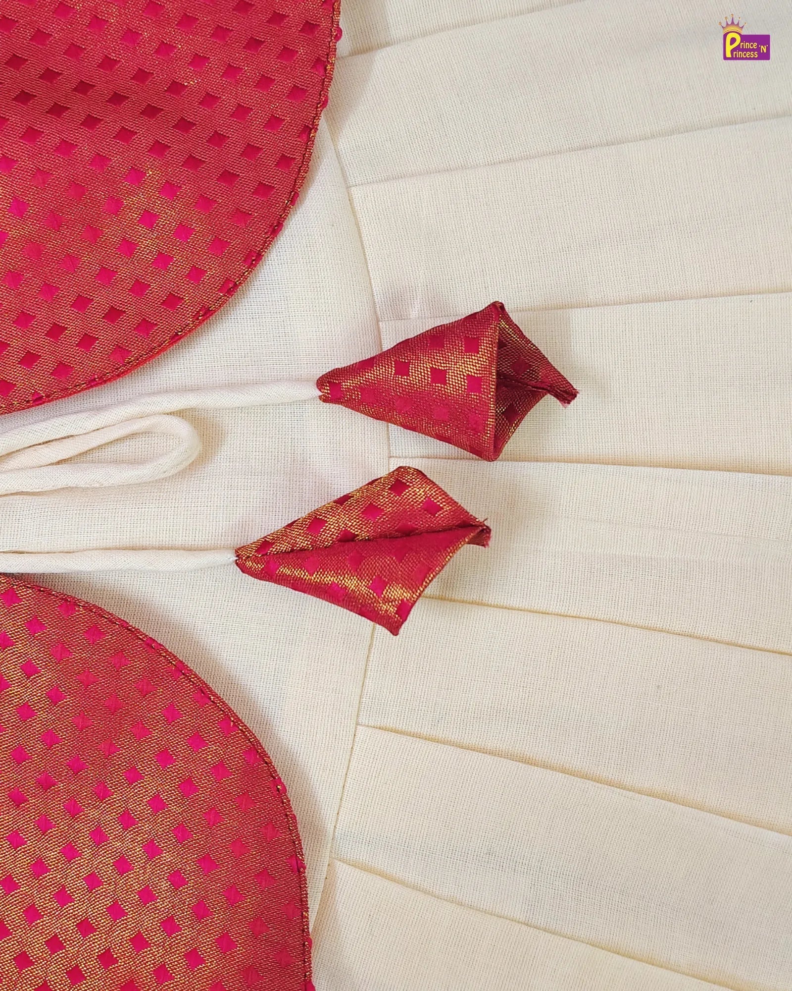 Red and gold patterned fabric with folded pieces on a white background