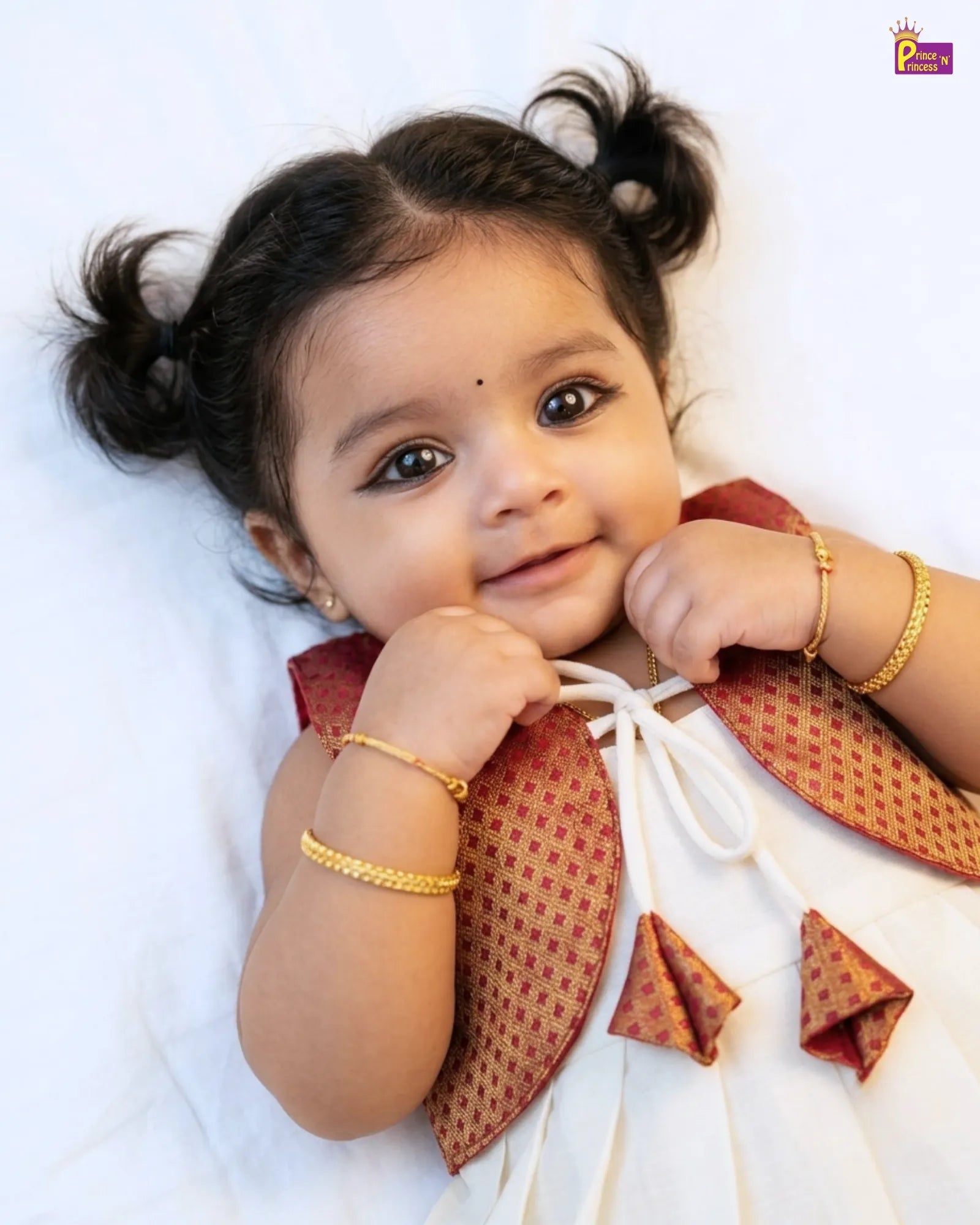 Baby wearing a traditional outfit with a white background