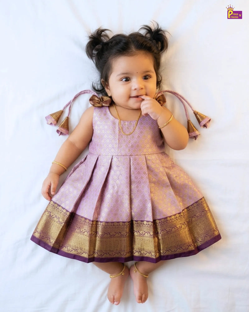 Child wearing a pink and gold traditional outfit on a white background