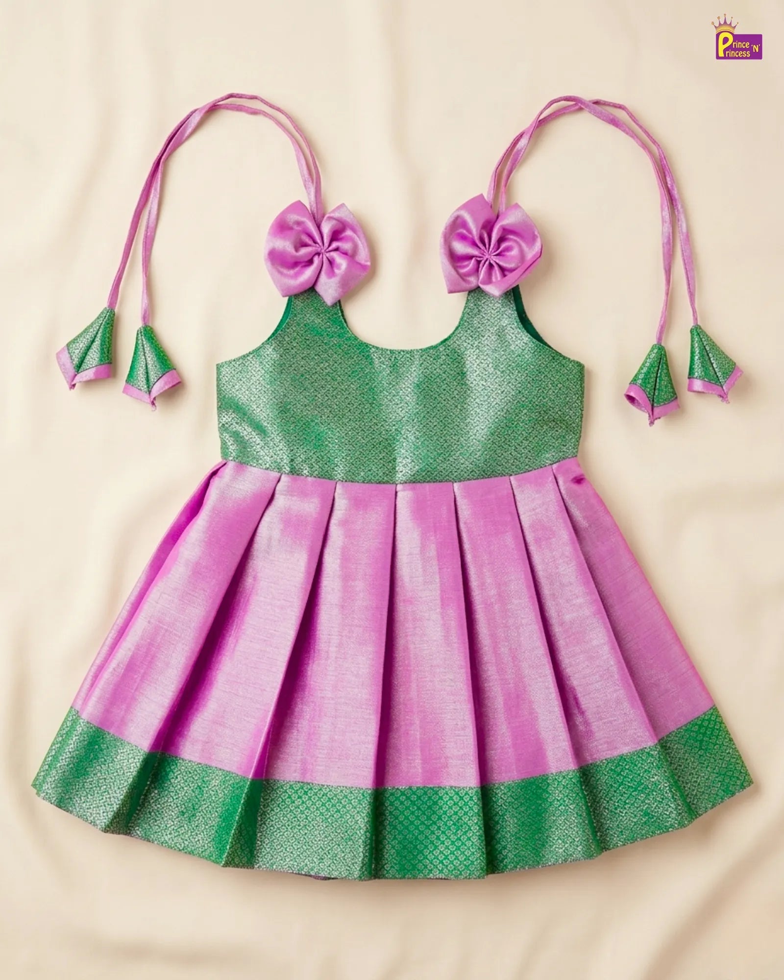Green and pink children's dress with floral headbands on a beige background