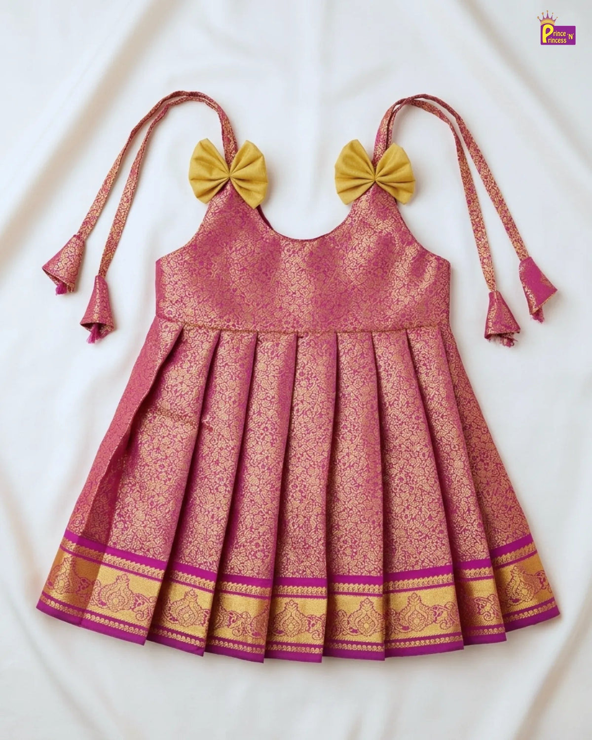 Pink and gold traditional dress with bow straps on a white background