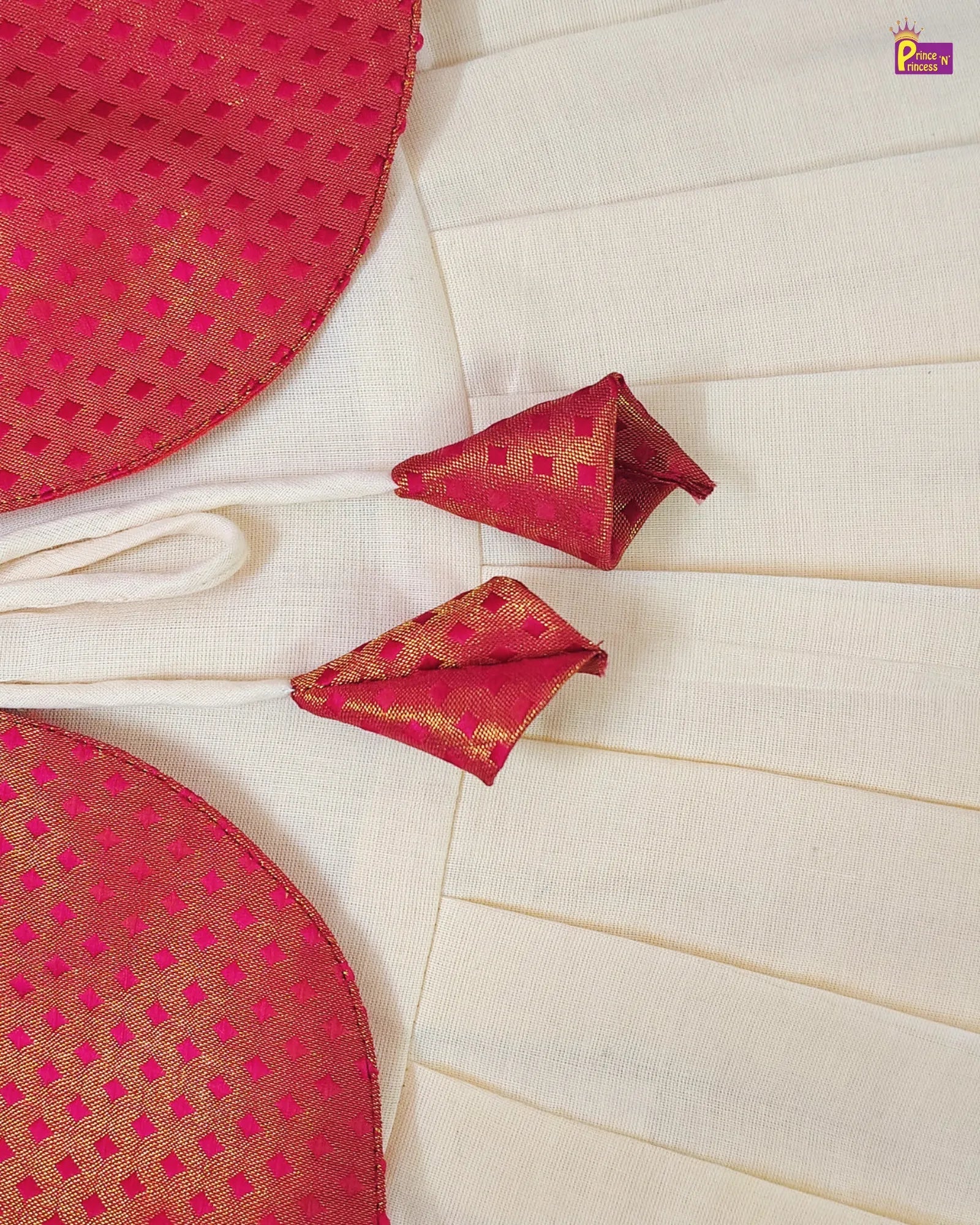Red and gold patterned fabric with folded pieces on a white background