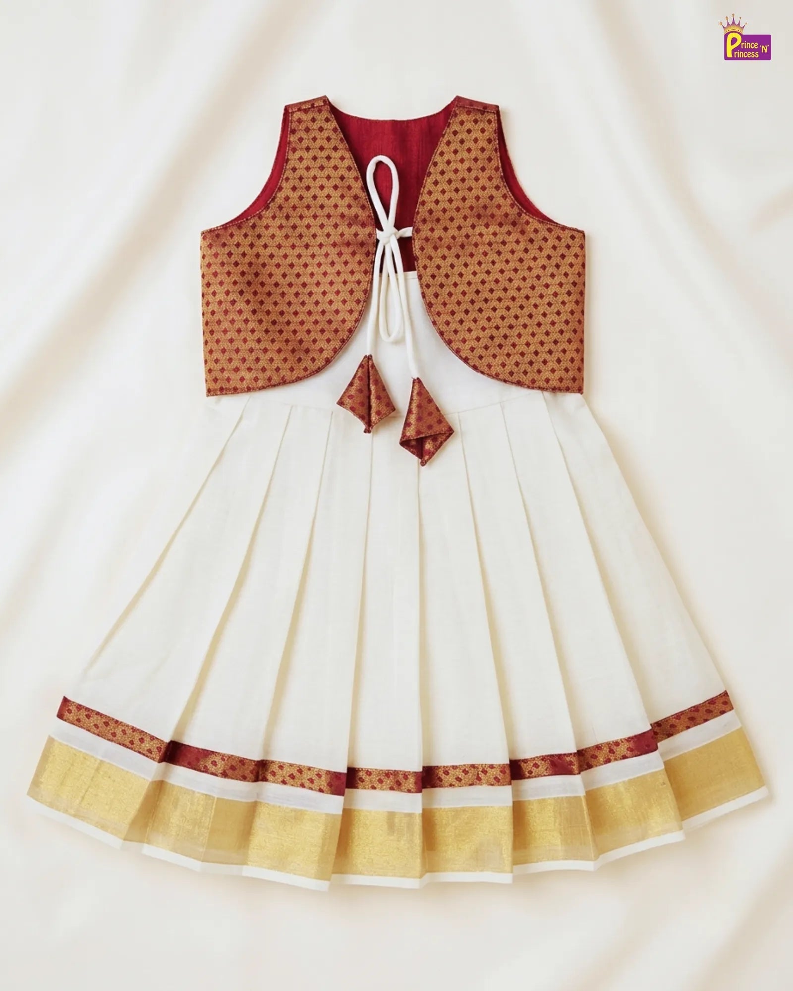 White dress with brown and red accents on a light beige background