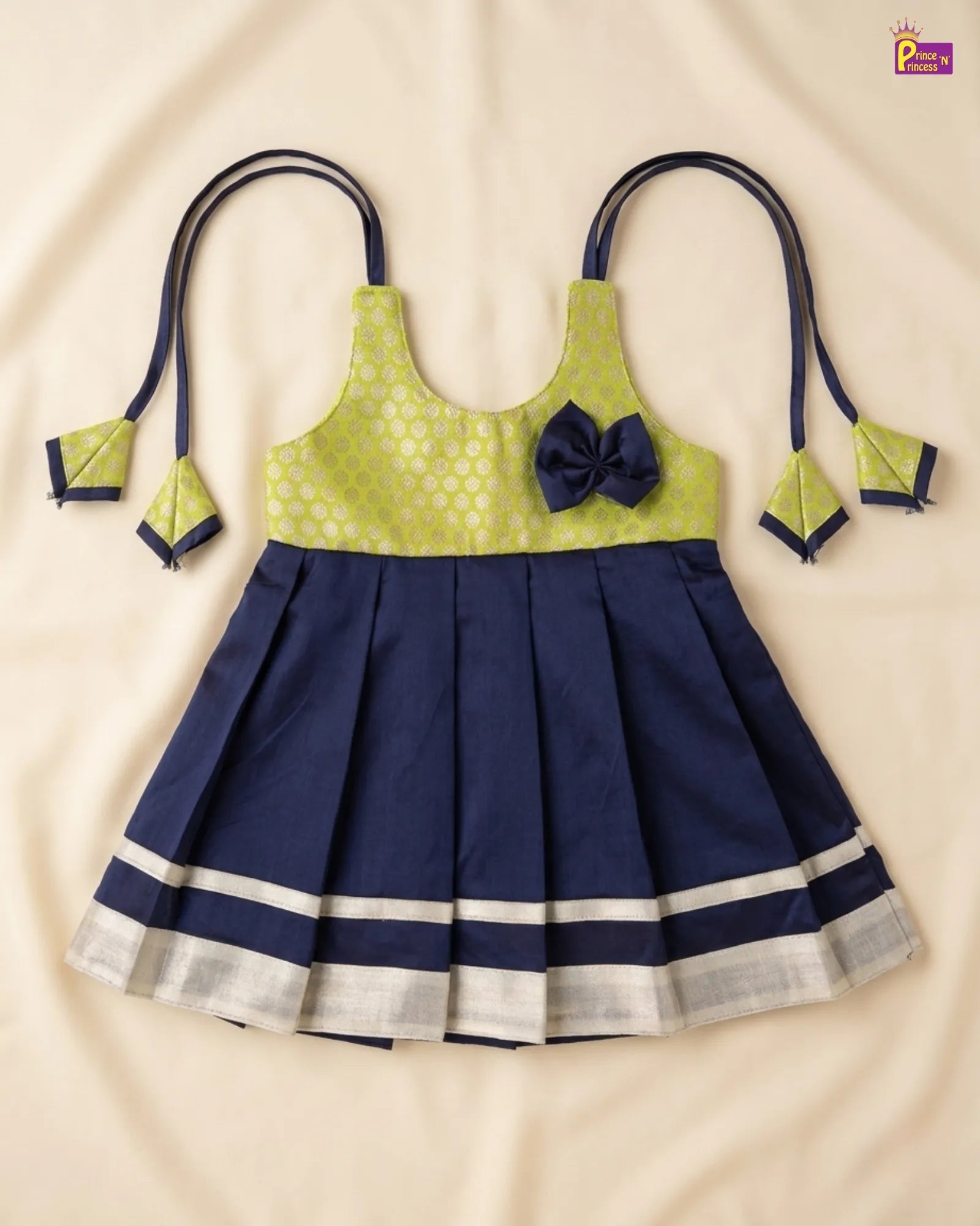 Navy blue and green traditional outfit with a bow on a beige background