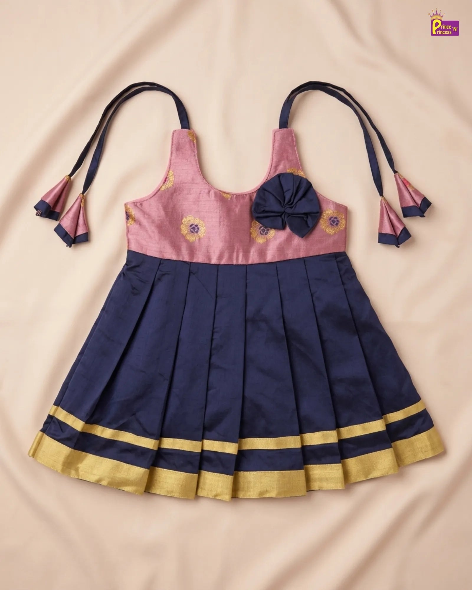 Navy blue and pink dress with floral embroidery on a beige background