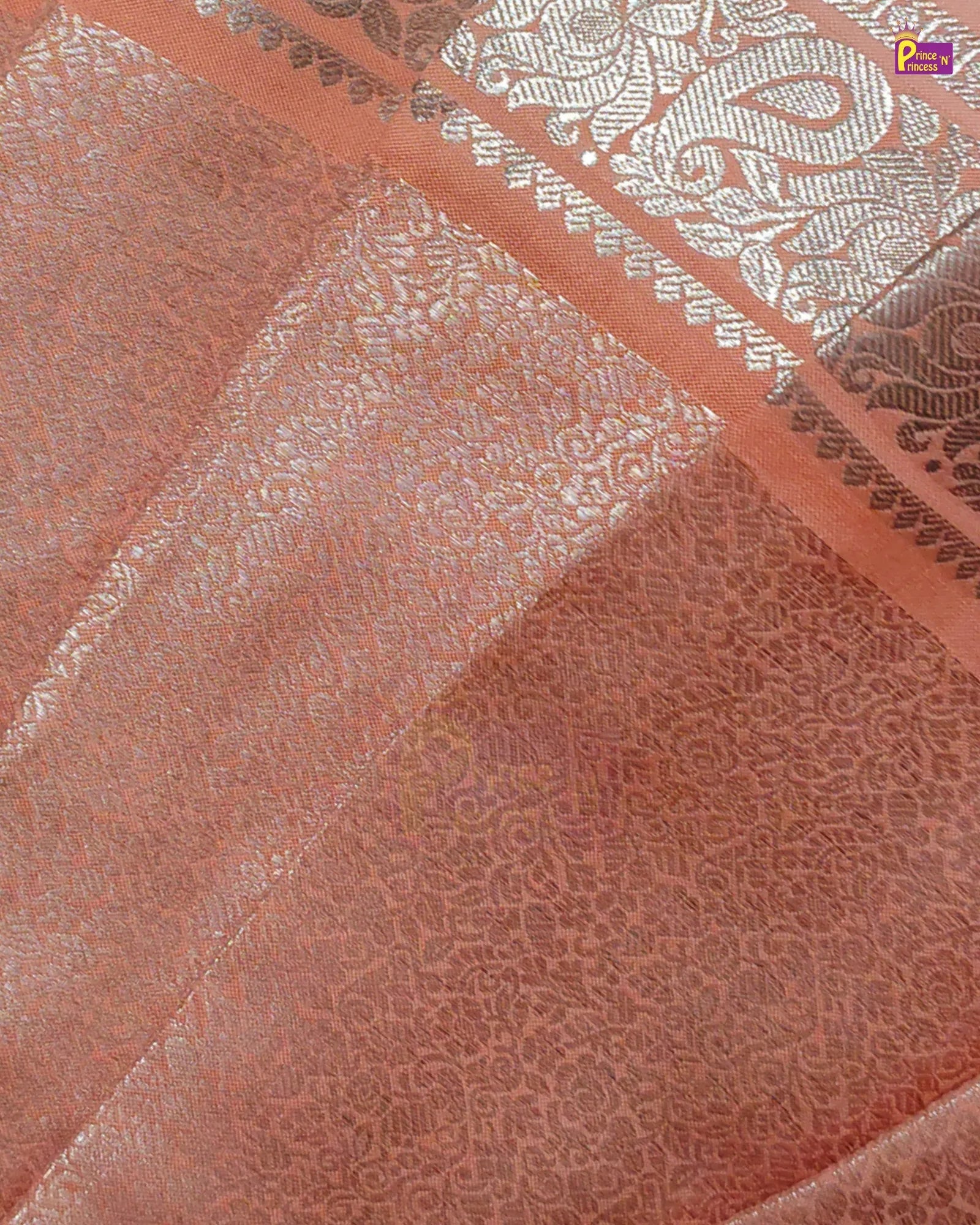 Close-up of peach-colored fabric with an allover tonal floral jacquard pattern and a decorative silver border.