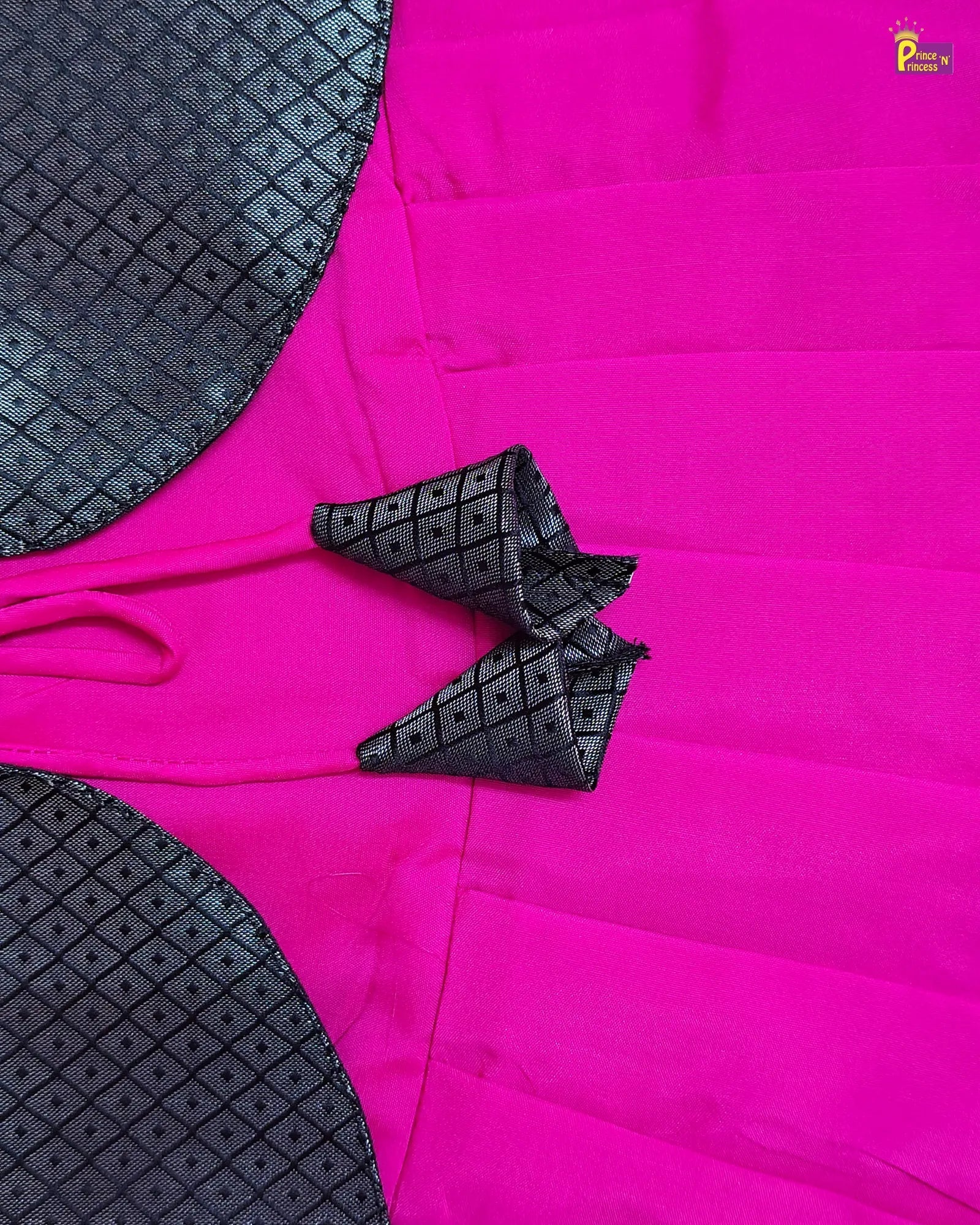 Pink fabric with black geometric patterns on a matching black fabric background
