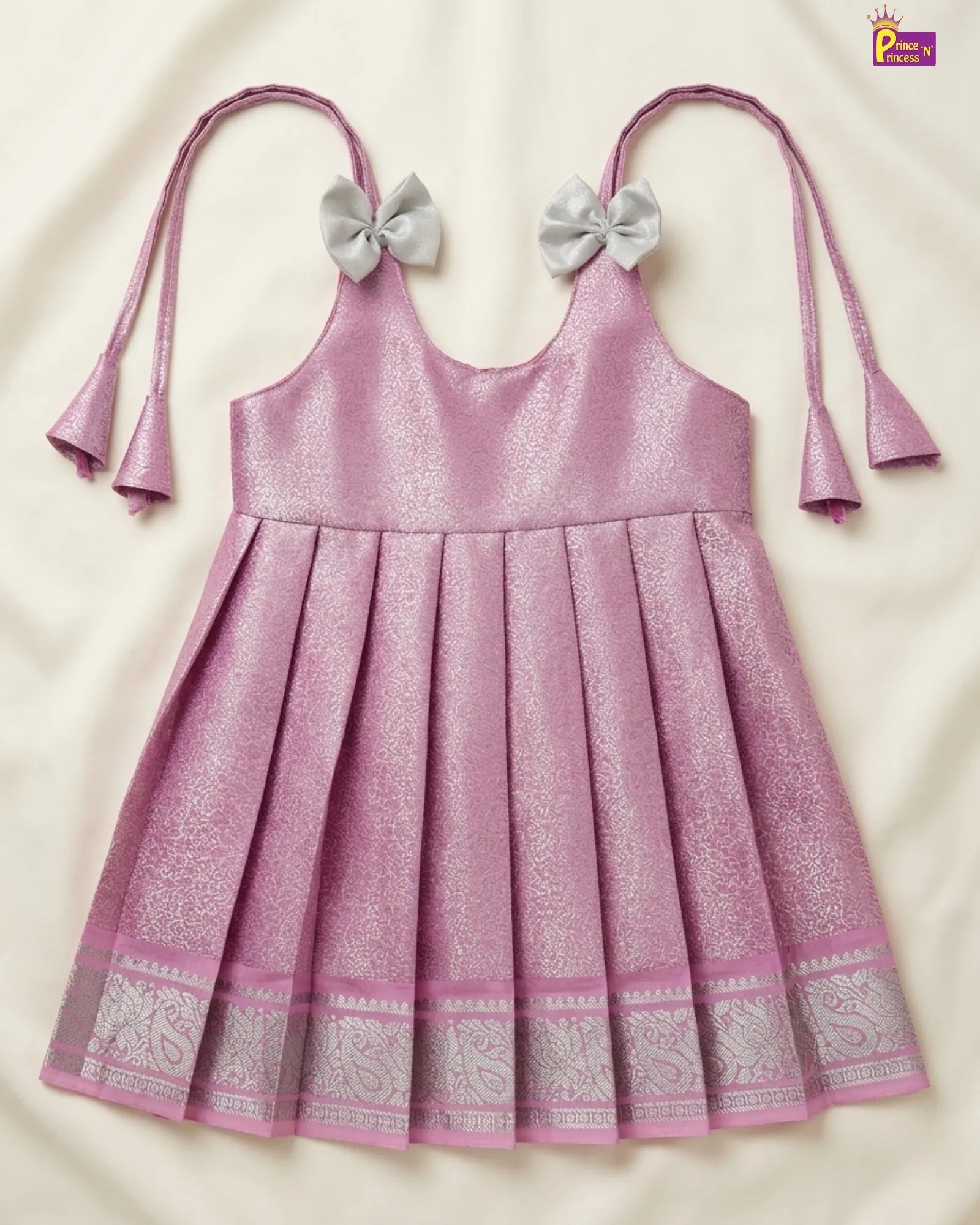 Pink dress with silver bows on a beige background
