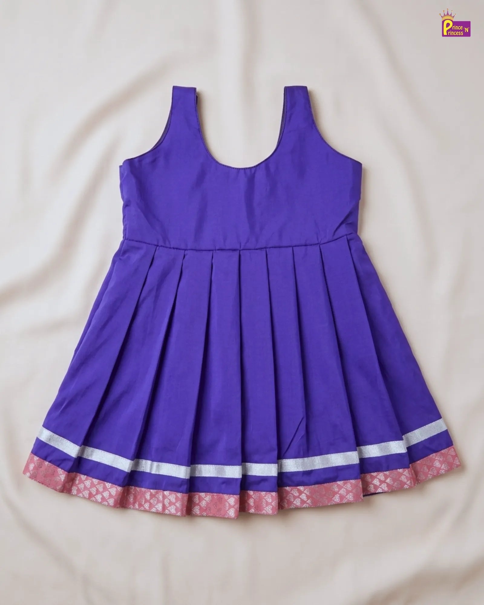 Purple dress with floral hem on a beige background