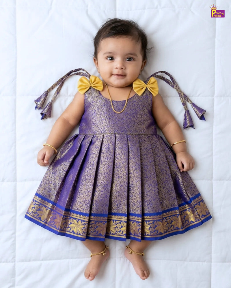 Baby wearing a purple and gold dress with yellow bows on a white background