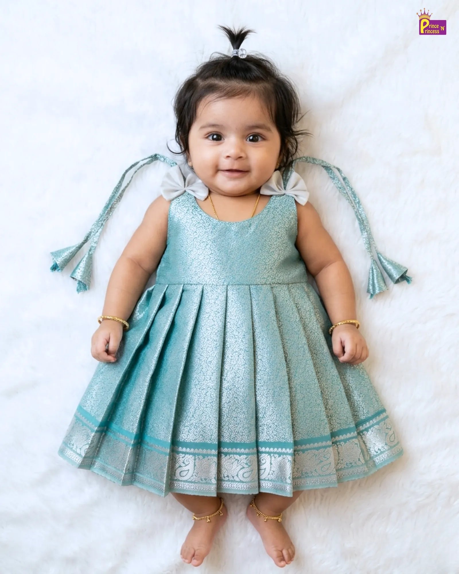 Baby in a light blue dress with decorative elements on a white background