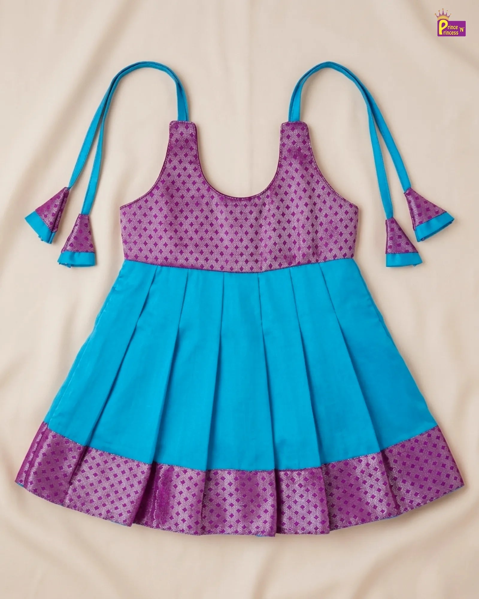 Children's dress with purple and blue pattern on a beige background