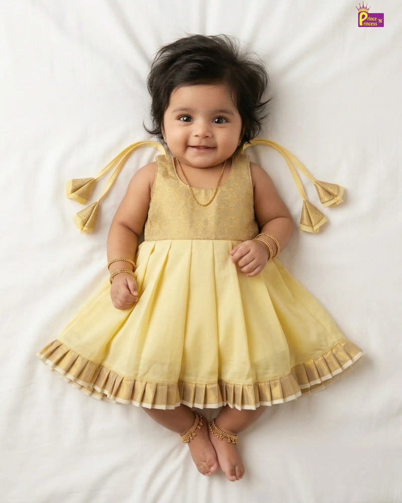 Baby wearing a yellow dress with tassels on a white background