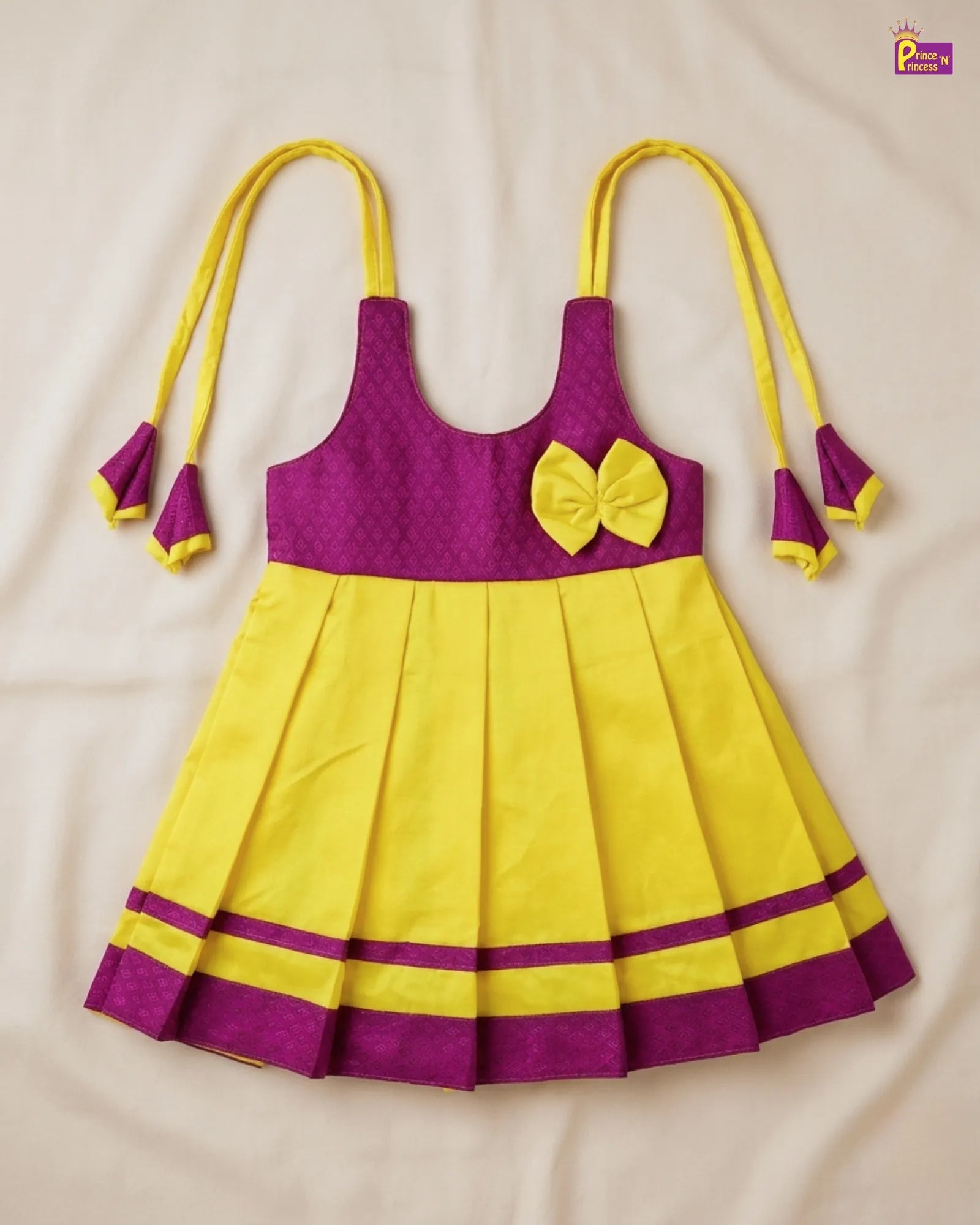Yellow and purple dress with a bow on a beige background