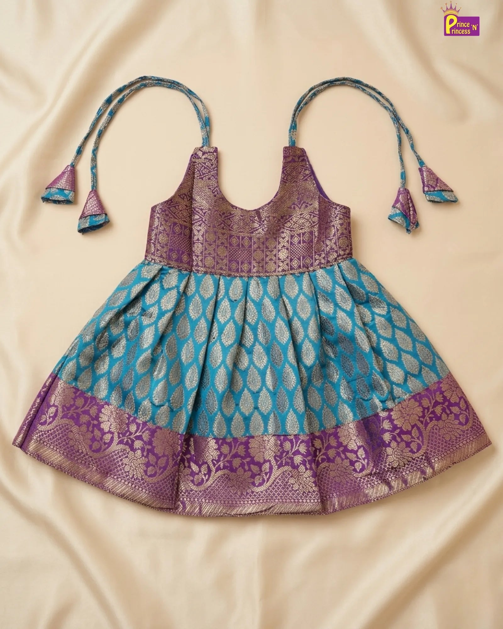 Children's dress with purple and blue pattern on a beige background