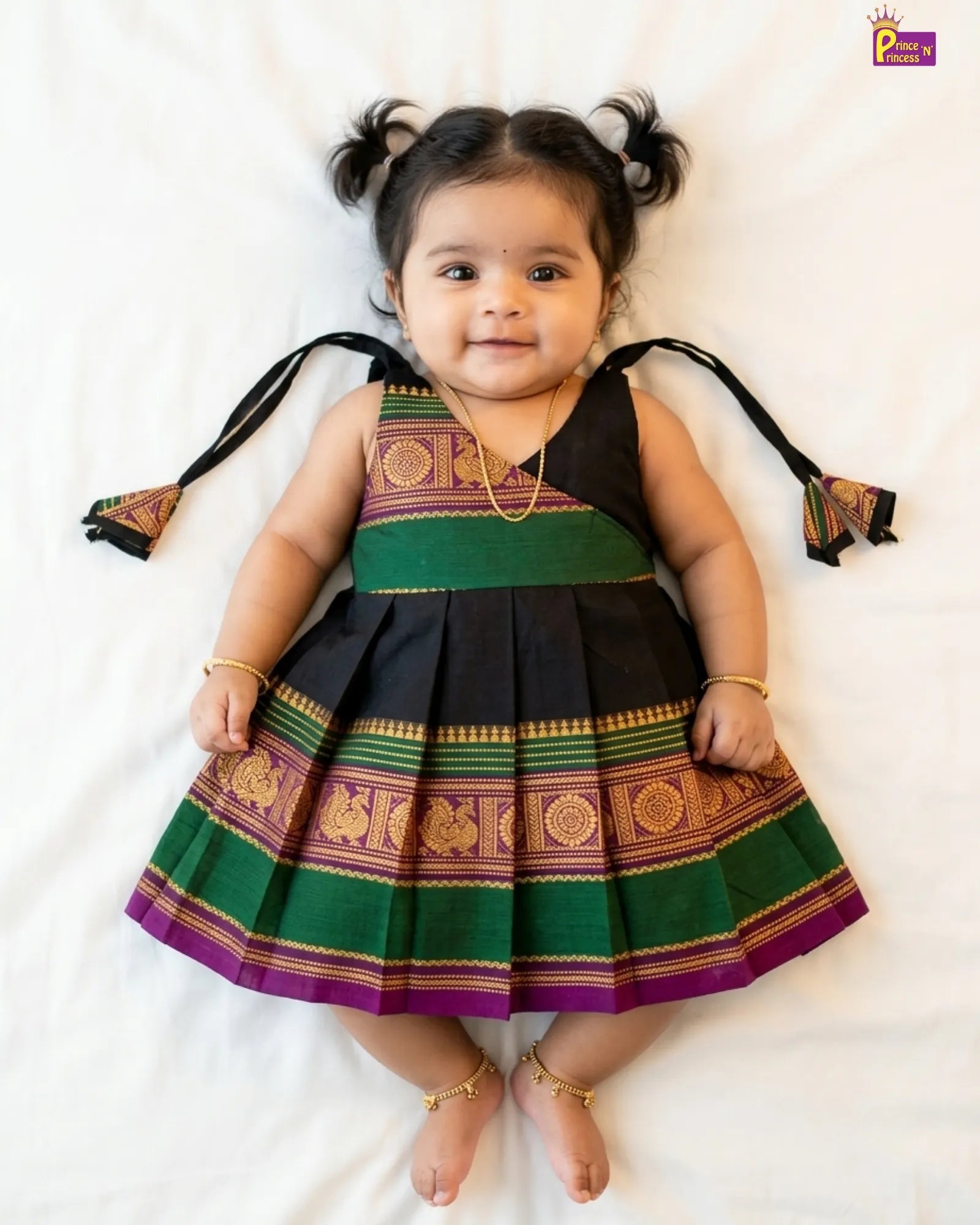 Child wearing a traditional outfit with green, purple, and black colors on a white background