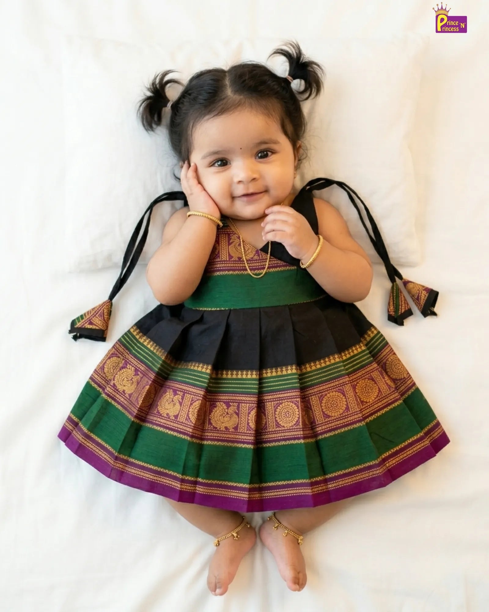 Child wearing a traditional outfit with green and black colors on a white background