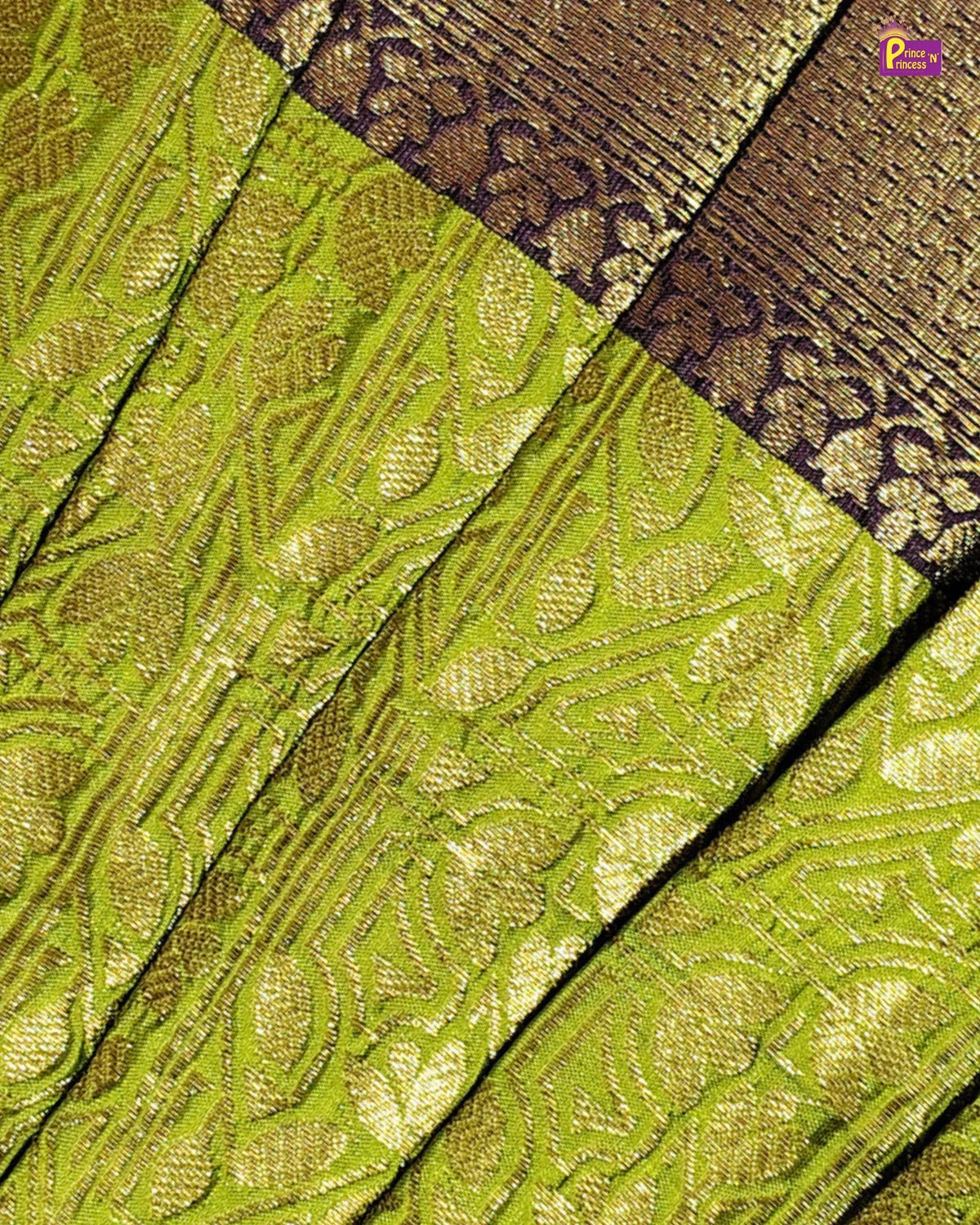 A close-up of a woven fabric with a bright chartreuse green base and metallic gold floral patterns, featuring a contrasting dark brown and gold patterned border.
